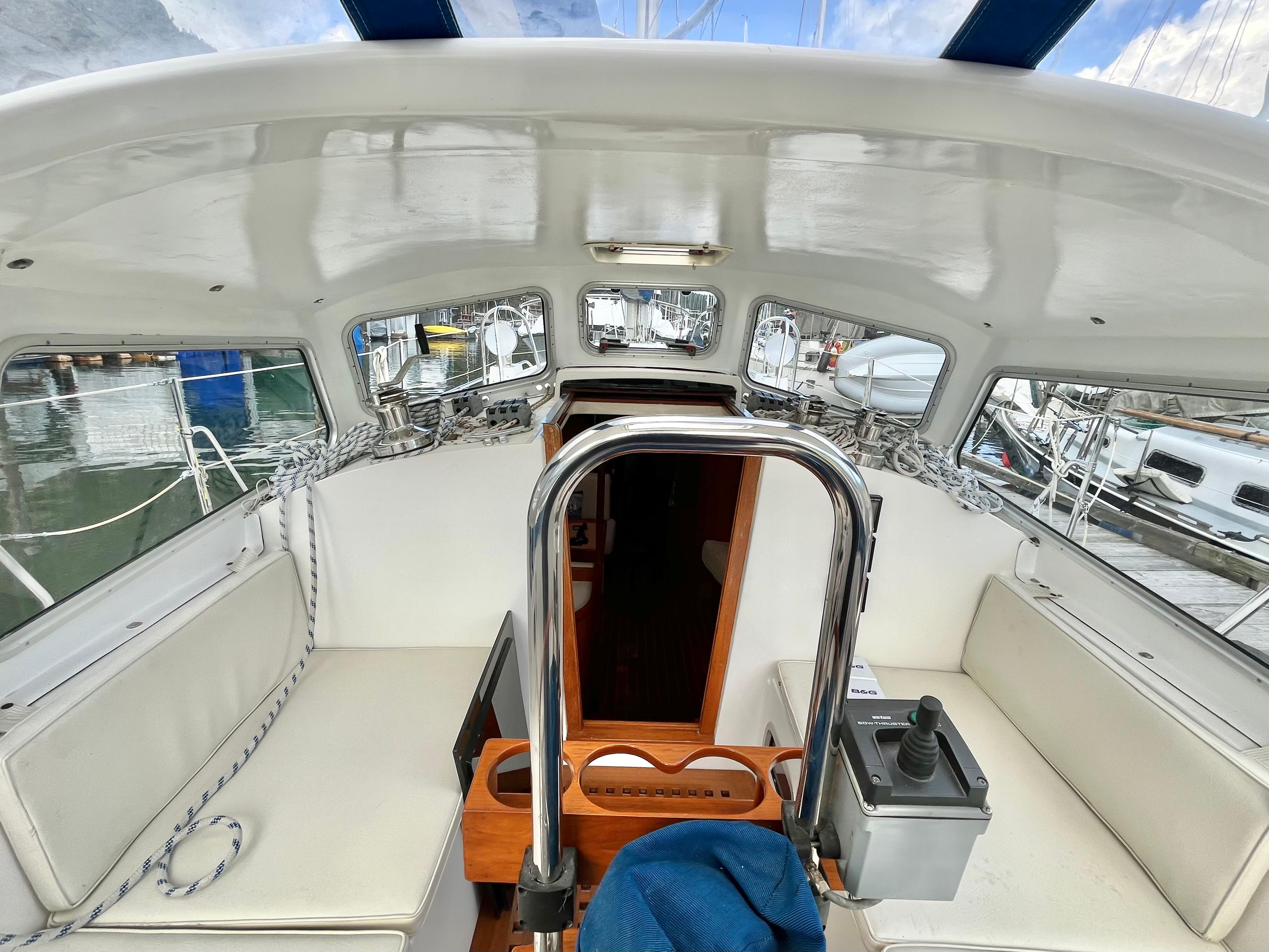 Interior view of a 2004 Nonsuch 33 sailboat cockpit with white seating and control panel.