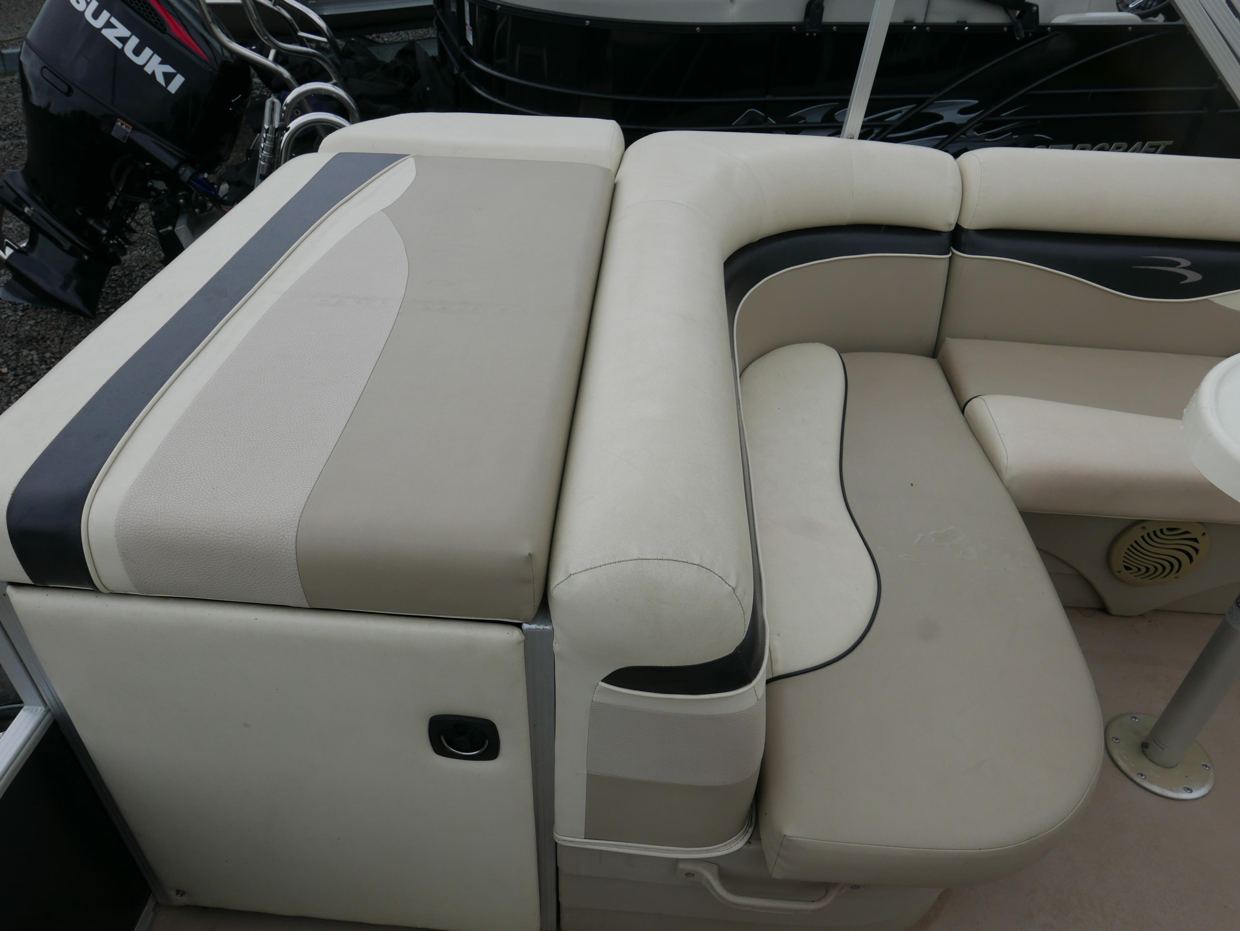 2013 Bennington 22SLX boat interior with beige and black seating, Suzuki engine visible.
