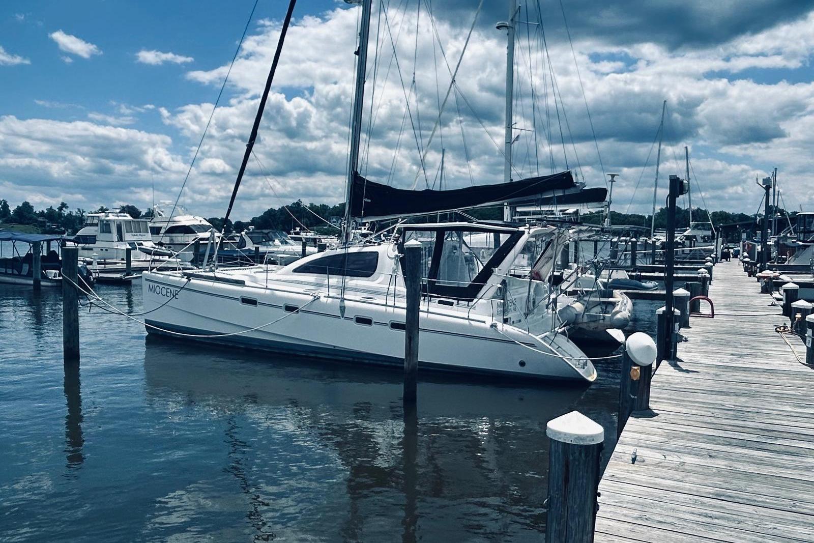 2001 Robertson & Caine Leopard yacht docked at a marina under a cloudy sky.