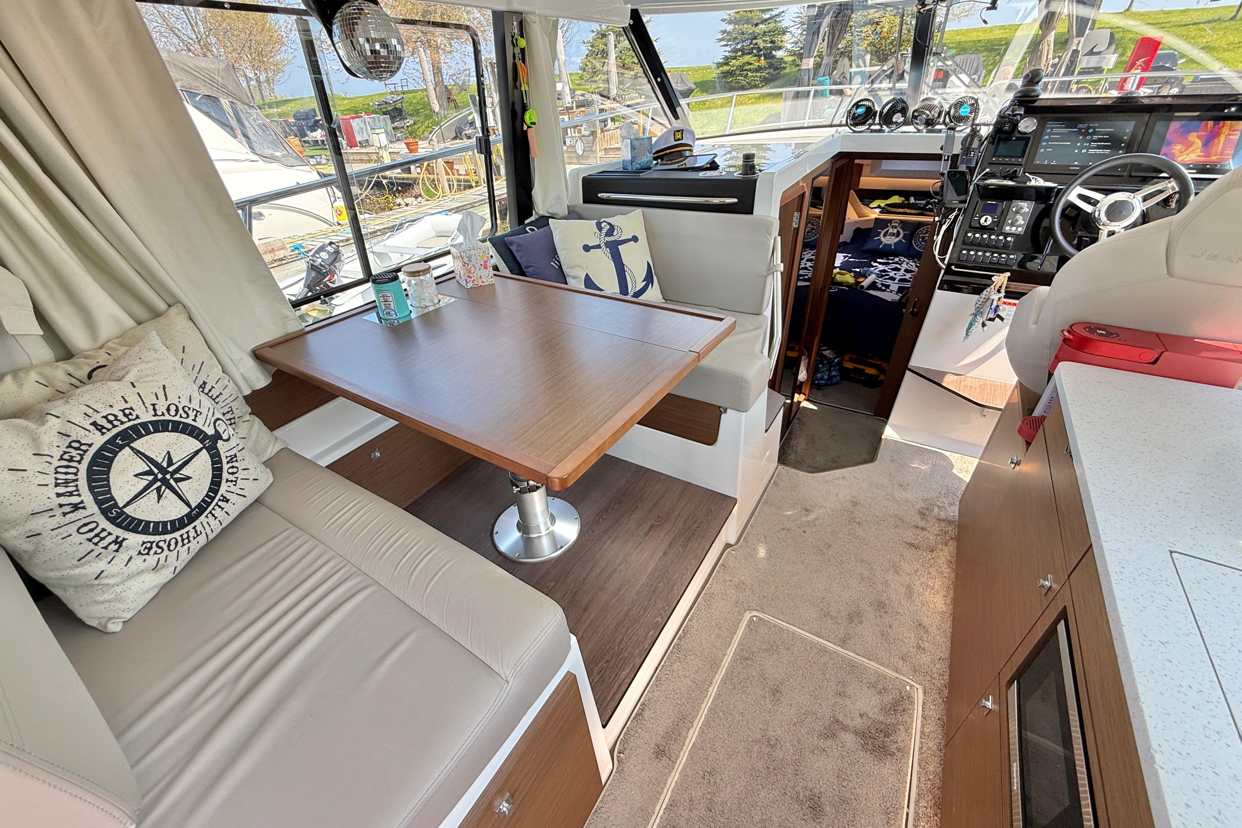 Interior of 2022 Jeanneau NC 1095 Fly, featuring cozy seating and modern navigation equipment.