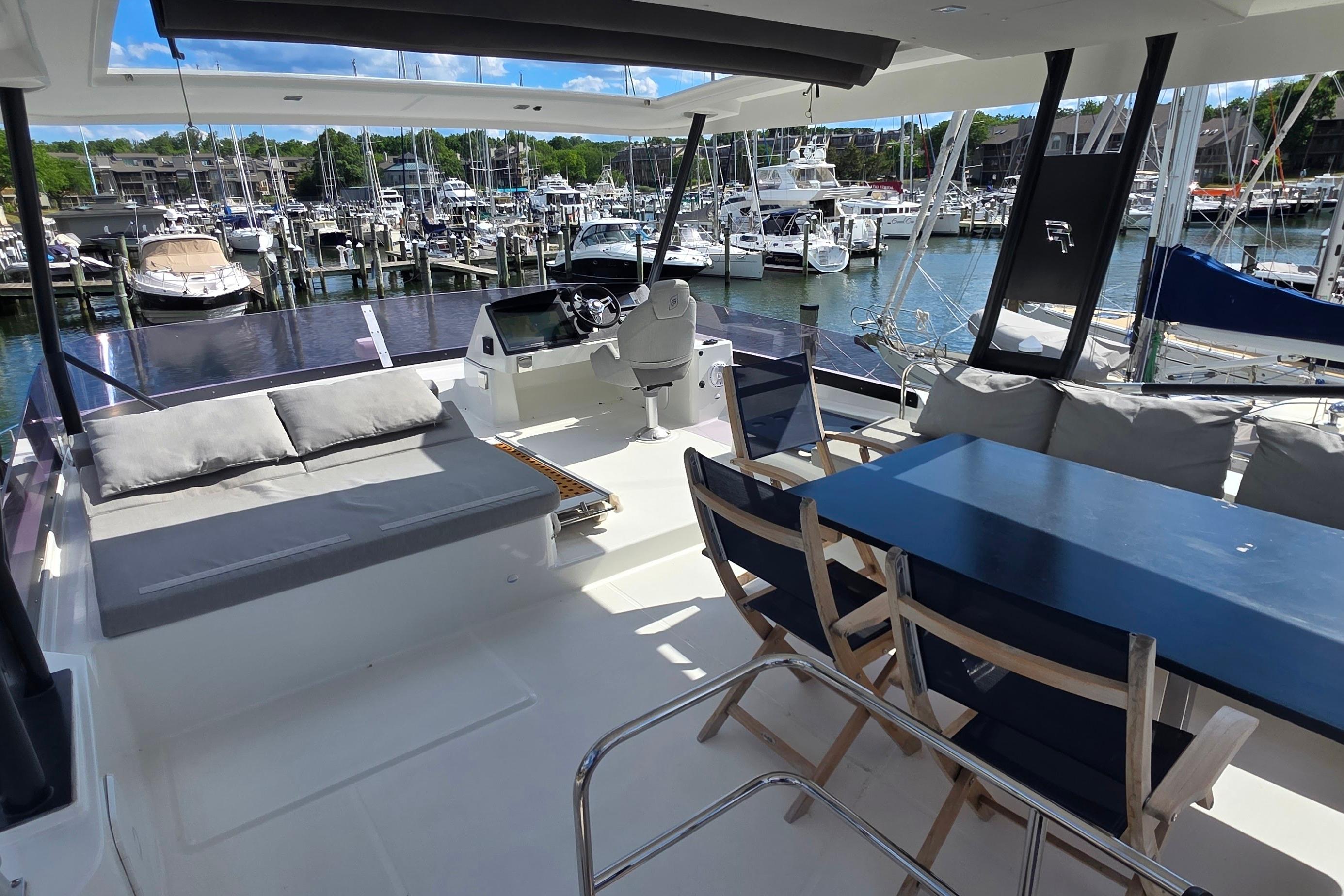 Luxurious 2018 Fountaine Pajot Motor Yacht 44 interior with seating and dining area at marina.