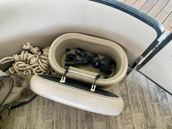 An open storage compartment on a boat with ropes and mounts.