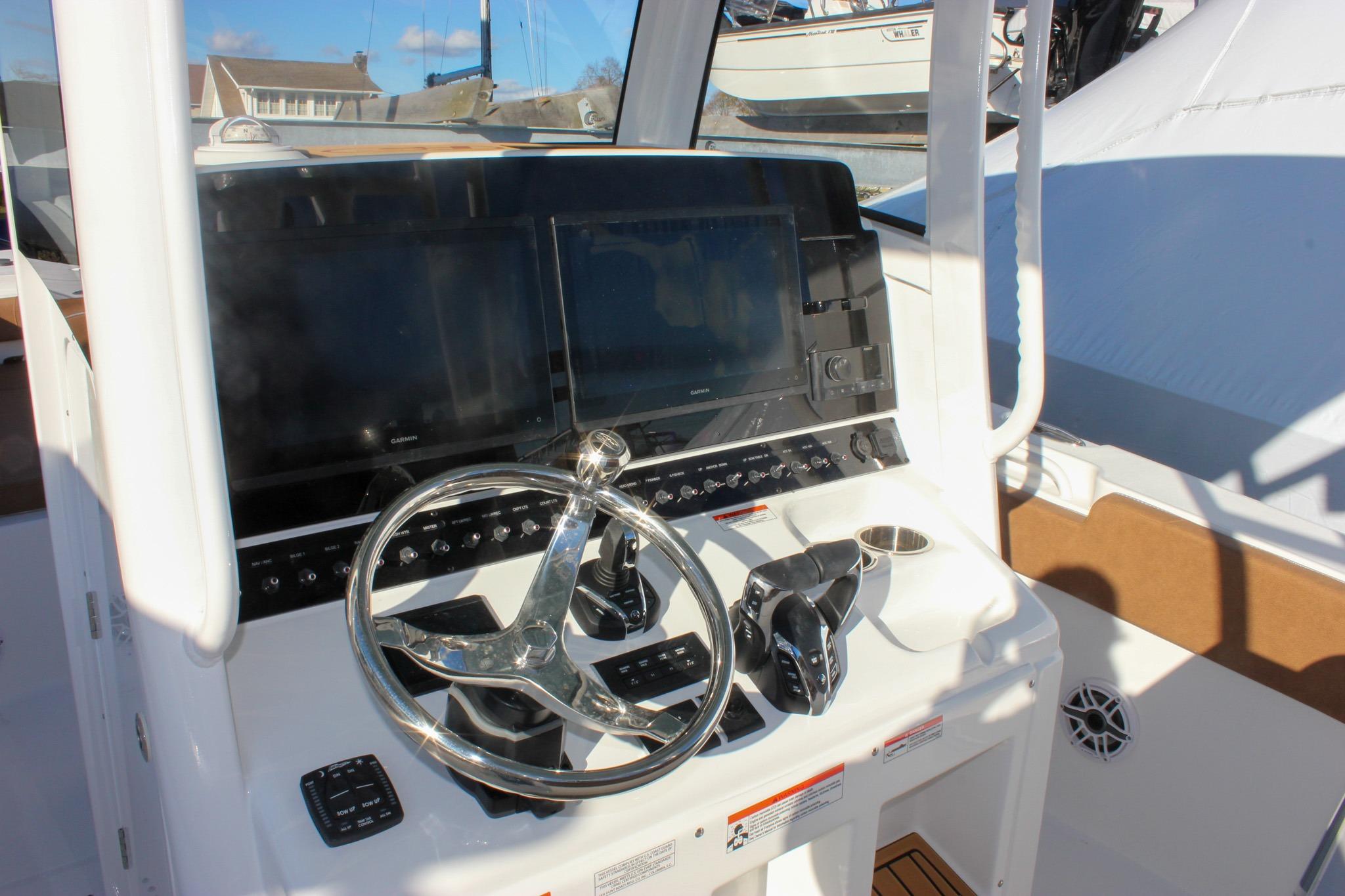 2026 Sea Hunt Ultra 285 SE boat dashboard with steering wheel and dual screens.