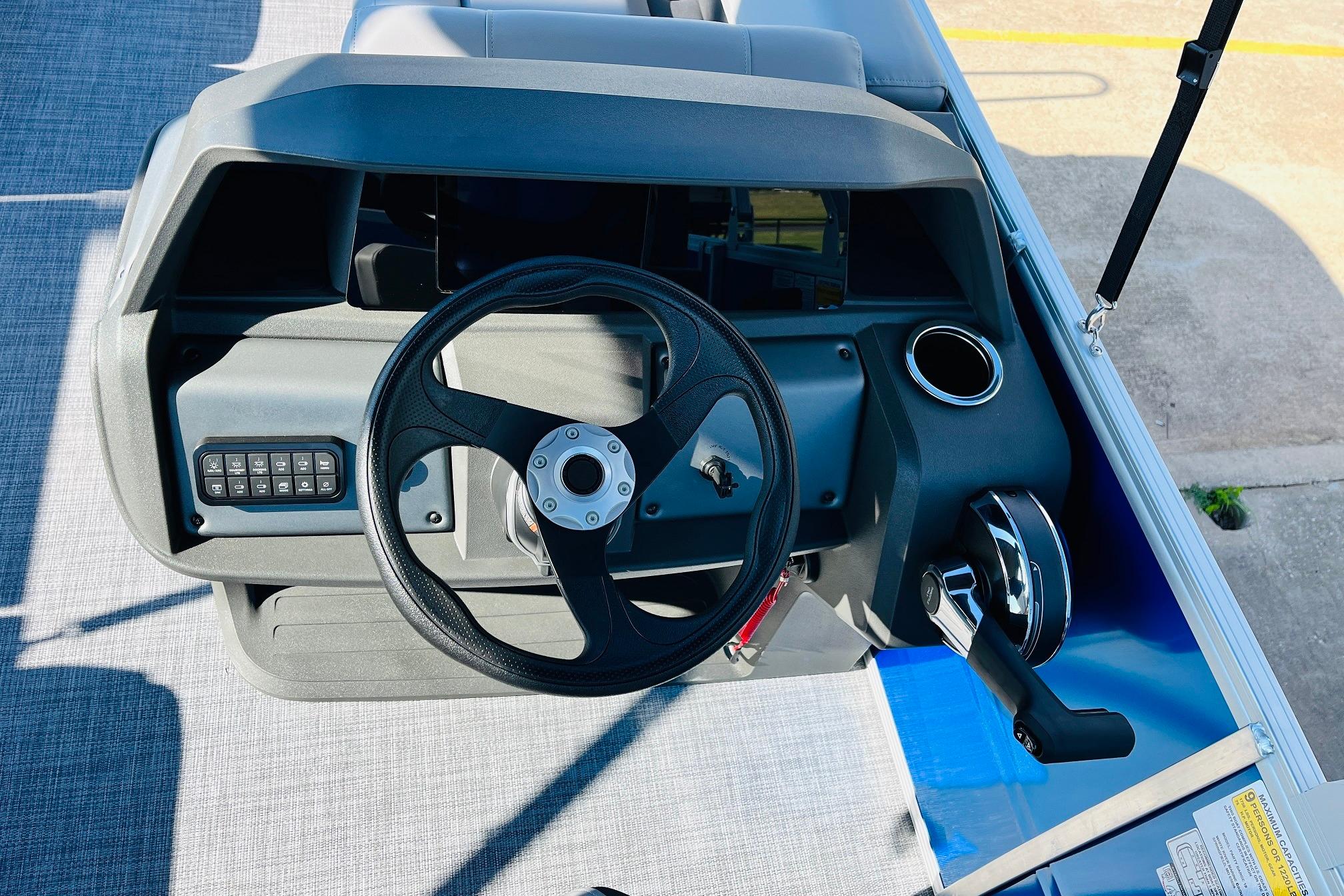 2026 Sun Tracker Party Barge 18 DLX steering console with controls and cup holder.