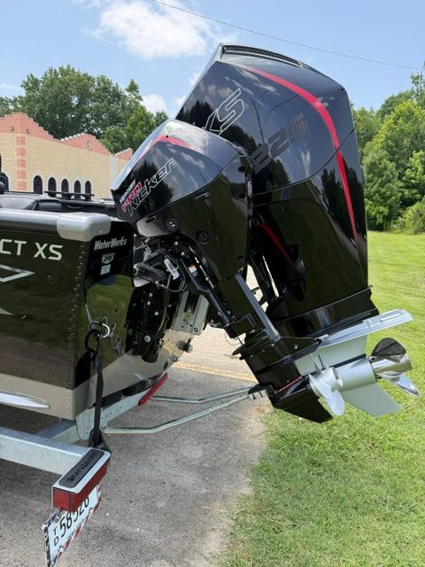 A Lund 2075 Impact XS boat with a powerful outboard motor, parked on a trailer.