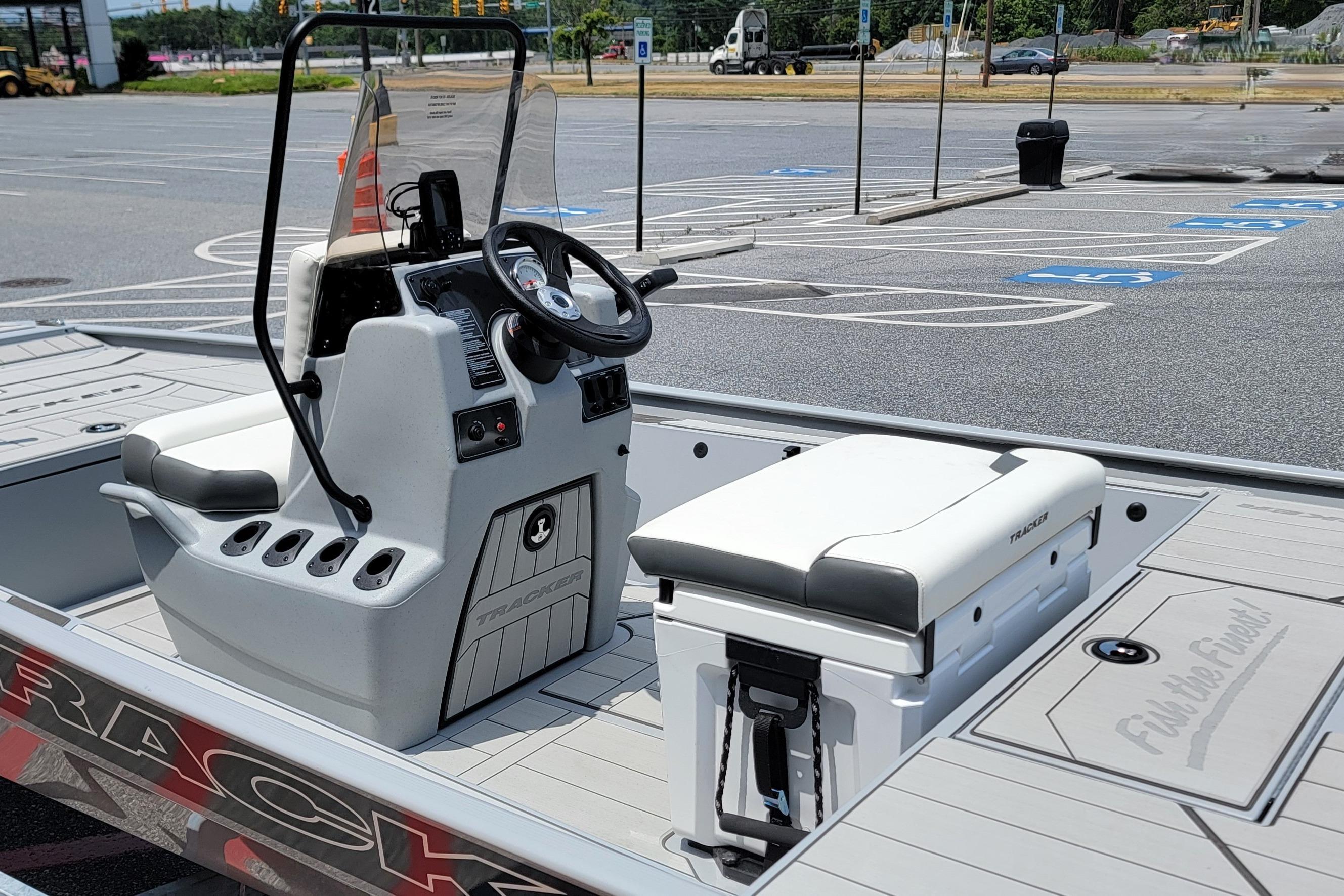 2026 Tracker Bass Tracker Classic CC boat interior with steering console and seating in a parking lot.