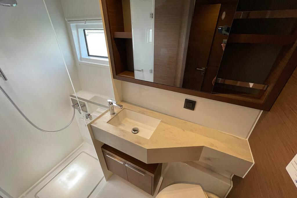 Modern bathroom in 2023 Lagoon 46 yacht with sleek sink and shower.