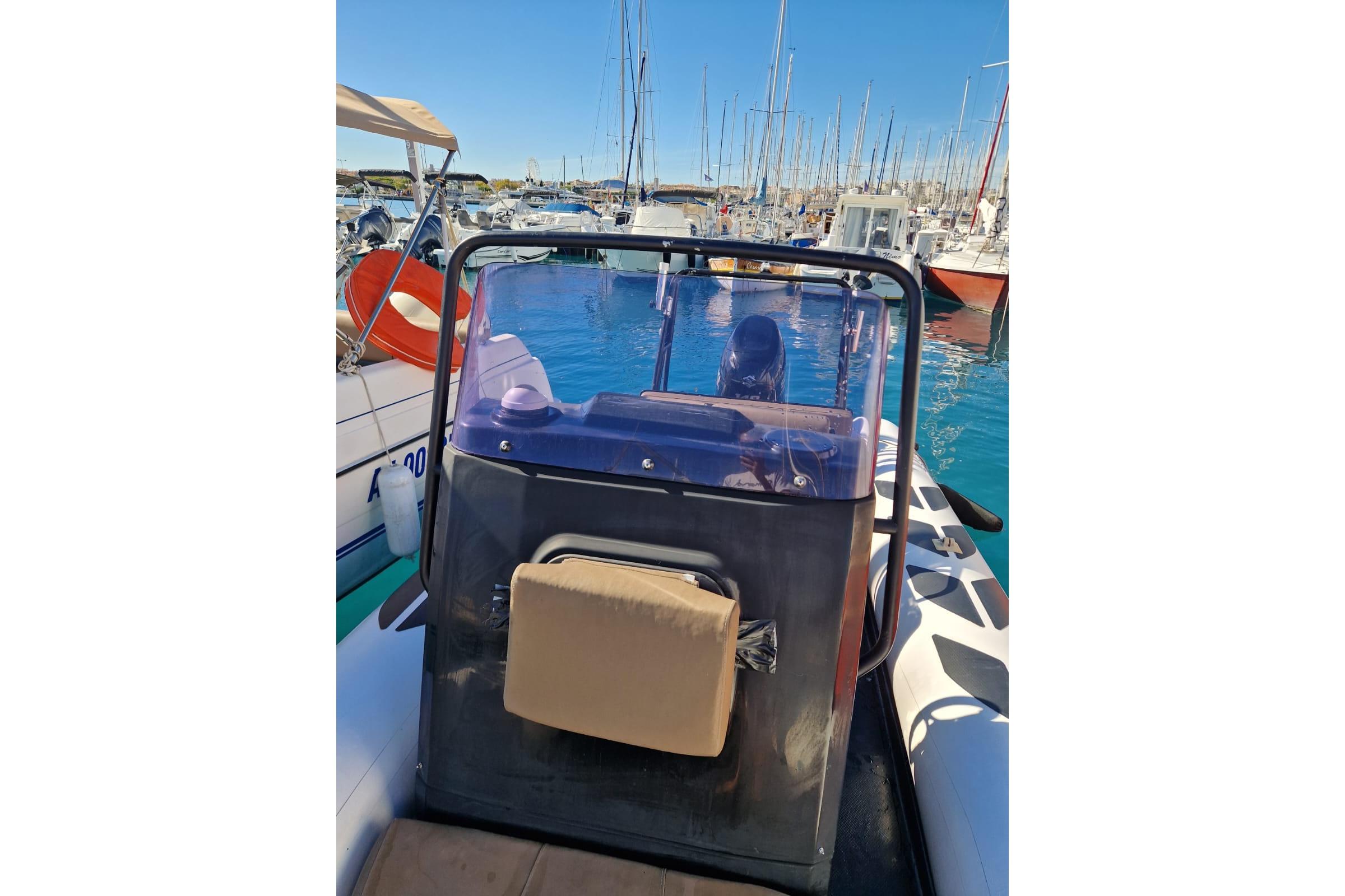 2018 Brig N610 boat docked in a marina with clear blue water and sailboats.