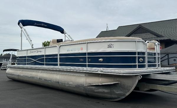 A 2018 South Bay S224CR pontoon boat on a trailer, featuring a blue and white design.