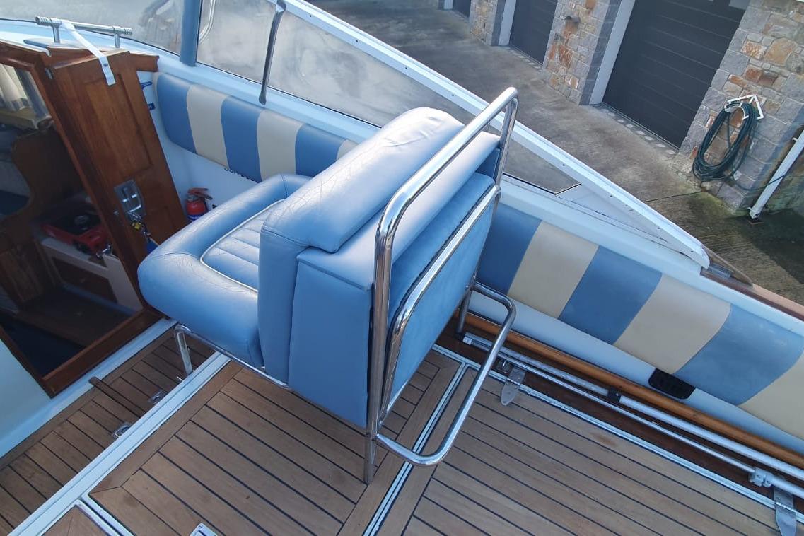 Blue and white interior of 1989 Fairey Spearfish MKIII boat with wooden flooring.