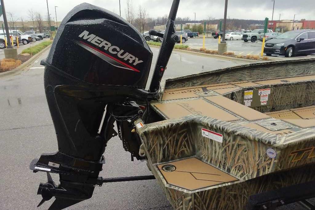 2026 Tracker Grizzly 1756 T Marsh boat with Mercury outboard motor in parking lot.