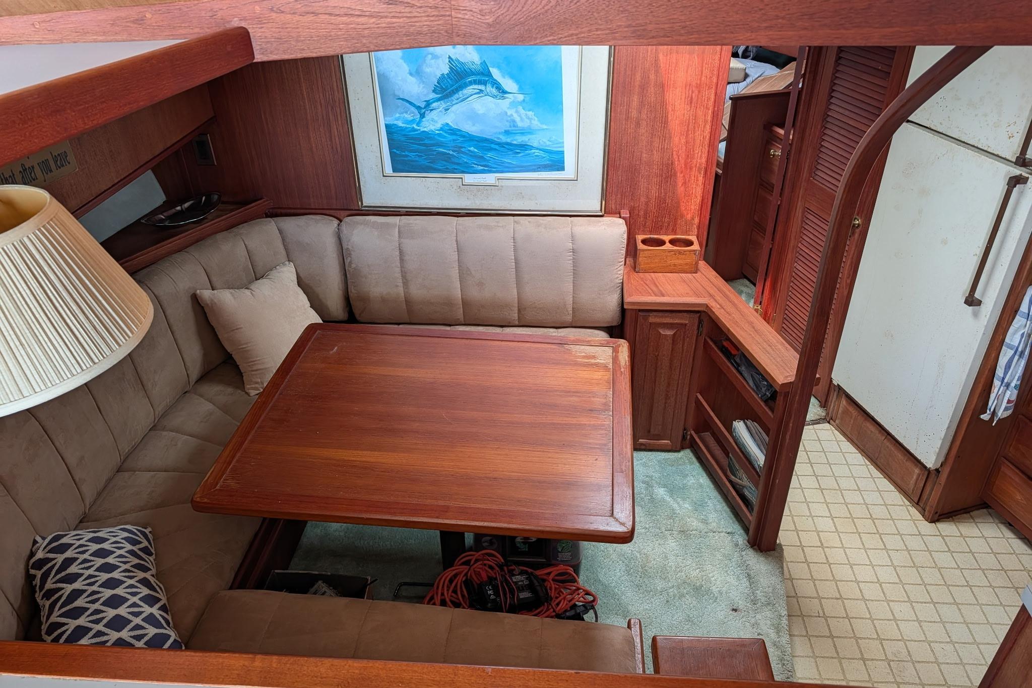 Interior of 1986 Viking Sportfish 41 with cozy dining area and marine artwork.