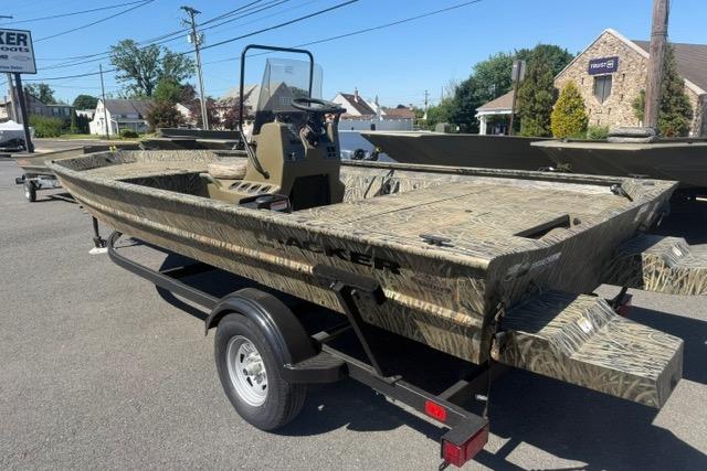 2026 Tracker Grizzly 1860 CC boat on trailer, camo design, parked outdoors.