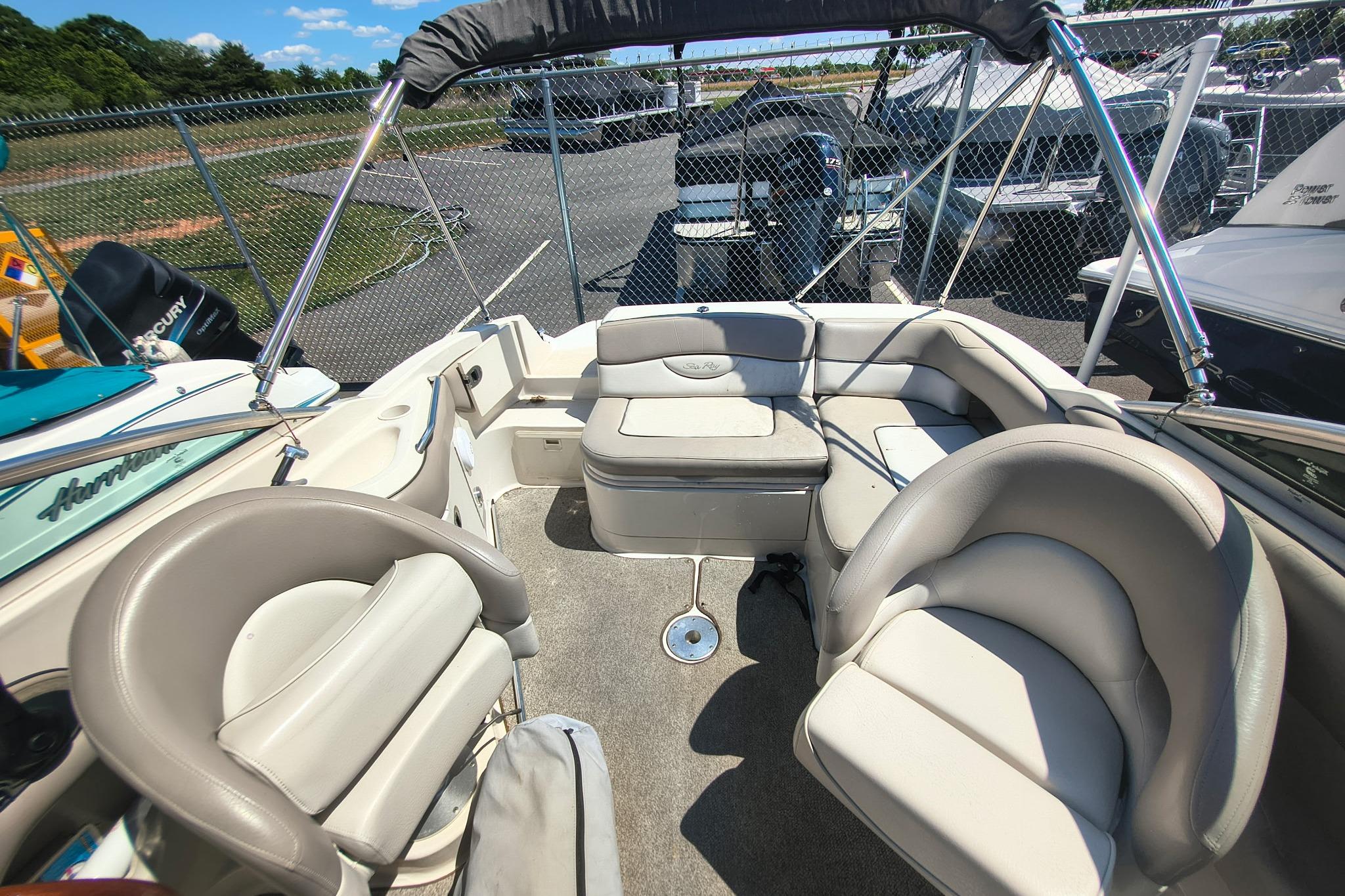 Interior of a 2004 Sun Deck 220 boat with beige seating and open canopy.