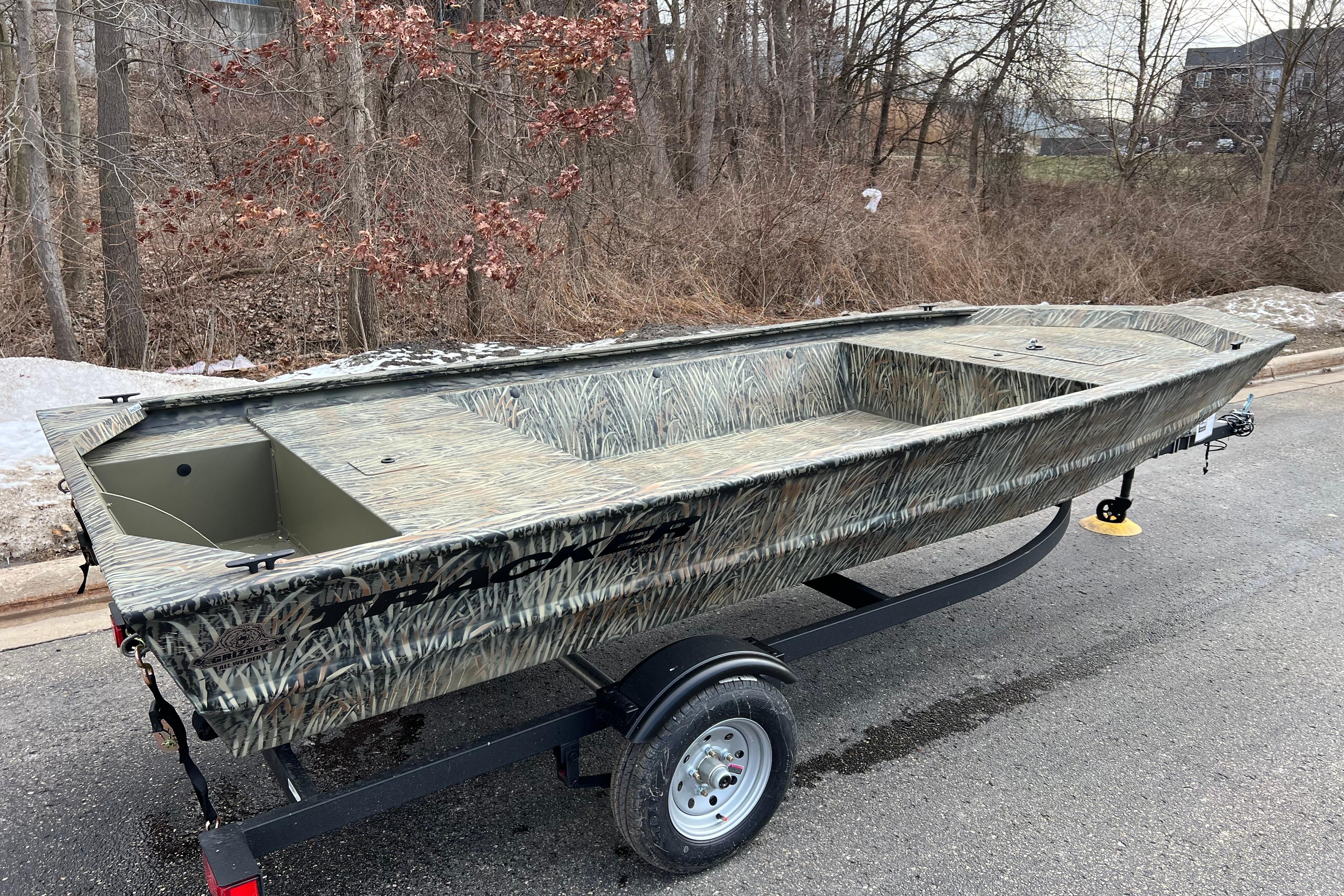 2026 Tracker Grizzly 1648 Utility boat on trailer, camo design, parked on road.