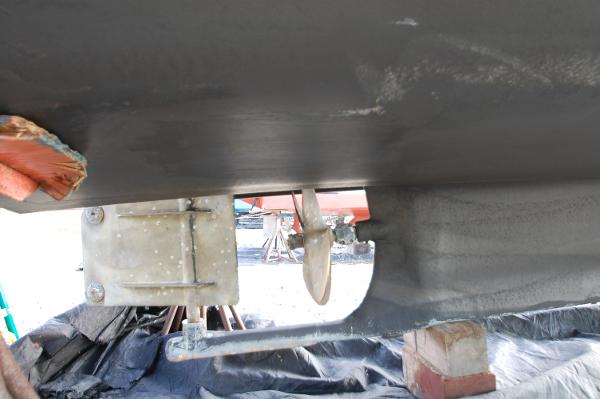 Close-up of a boat's underside showing the propeller and rudder.