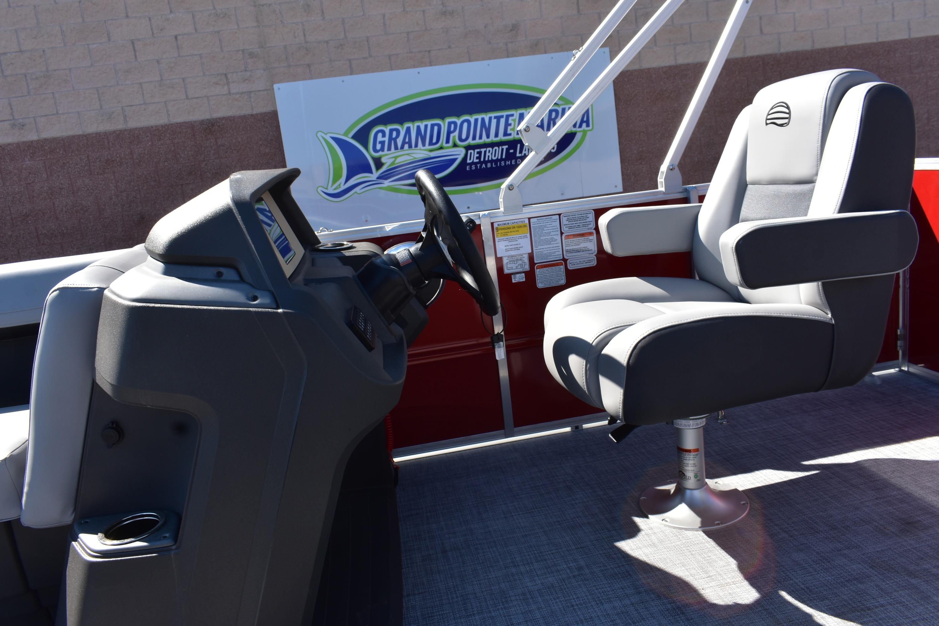 2026 Sun Tracker Party Barge 18 DLX interior with steering console and captain's chair.