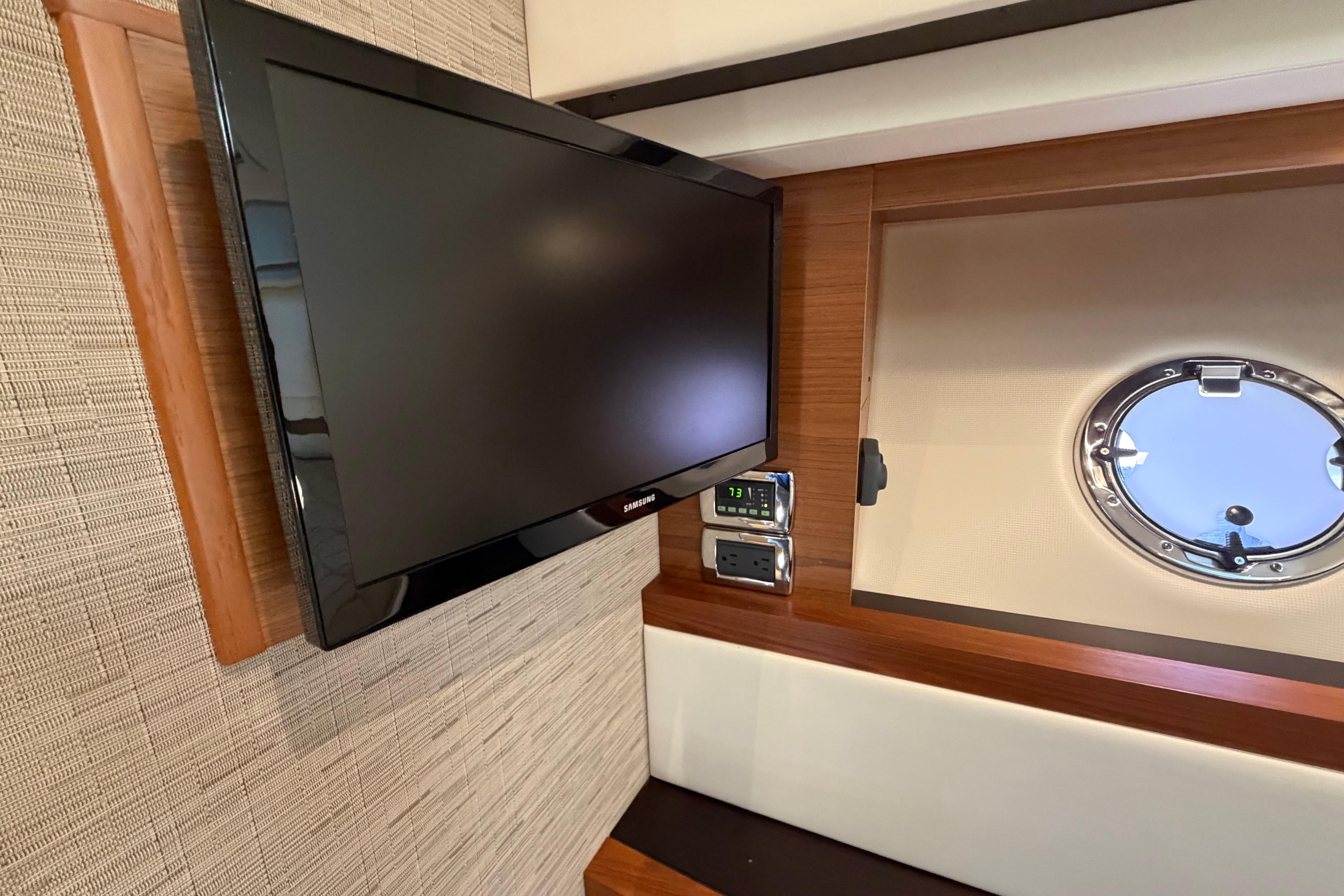 Flat-screen TV and porthole in 2016 Tiara Yachts C39 Coupe interior.
