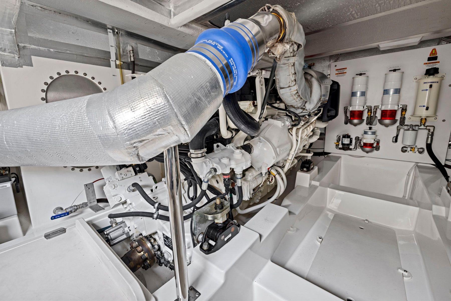 Engine room of 2014 Maritimo M50 yacht, showcasing mechanical components and piping.