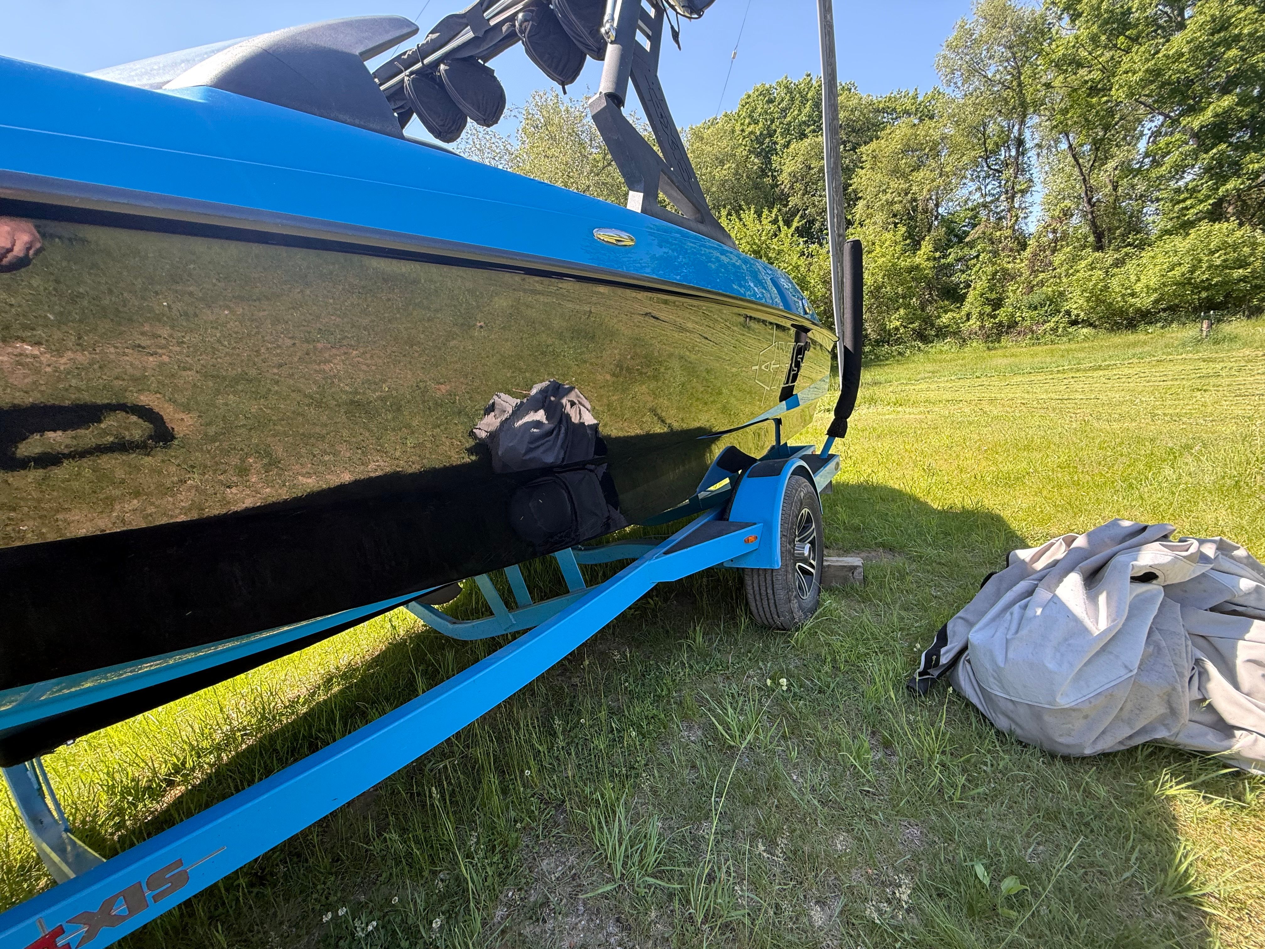 2015 Malibu Axis A20 boat on trailer in grassy area.