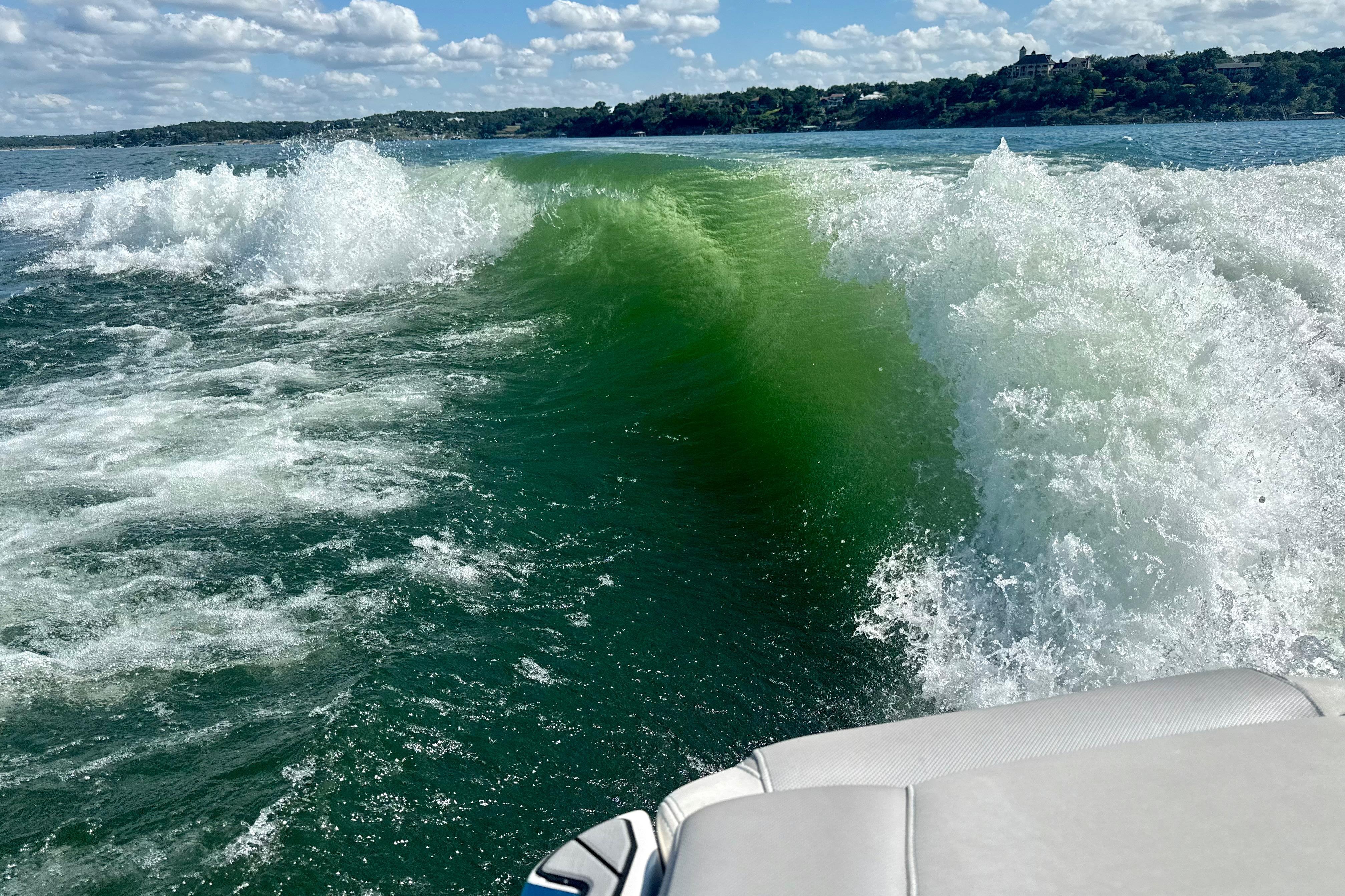 Wake created by a 2017 Malibu M235 boat on a sunny lake day.