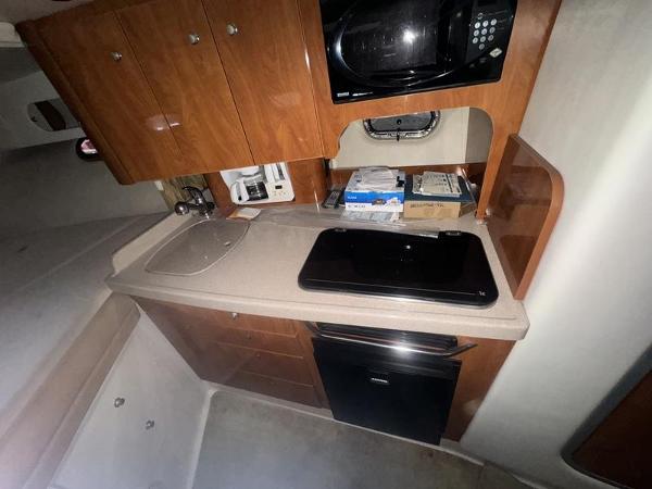 2005 Four Winns 298 Vista boat kitchen with microwave, sink, and storage cabinets.