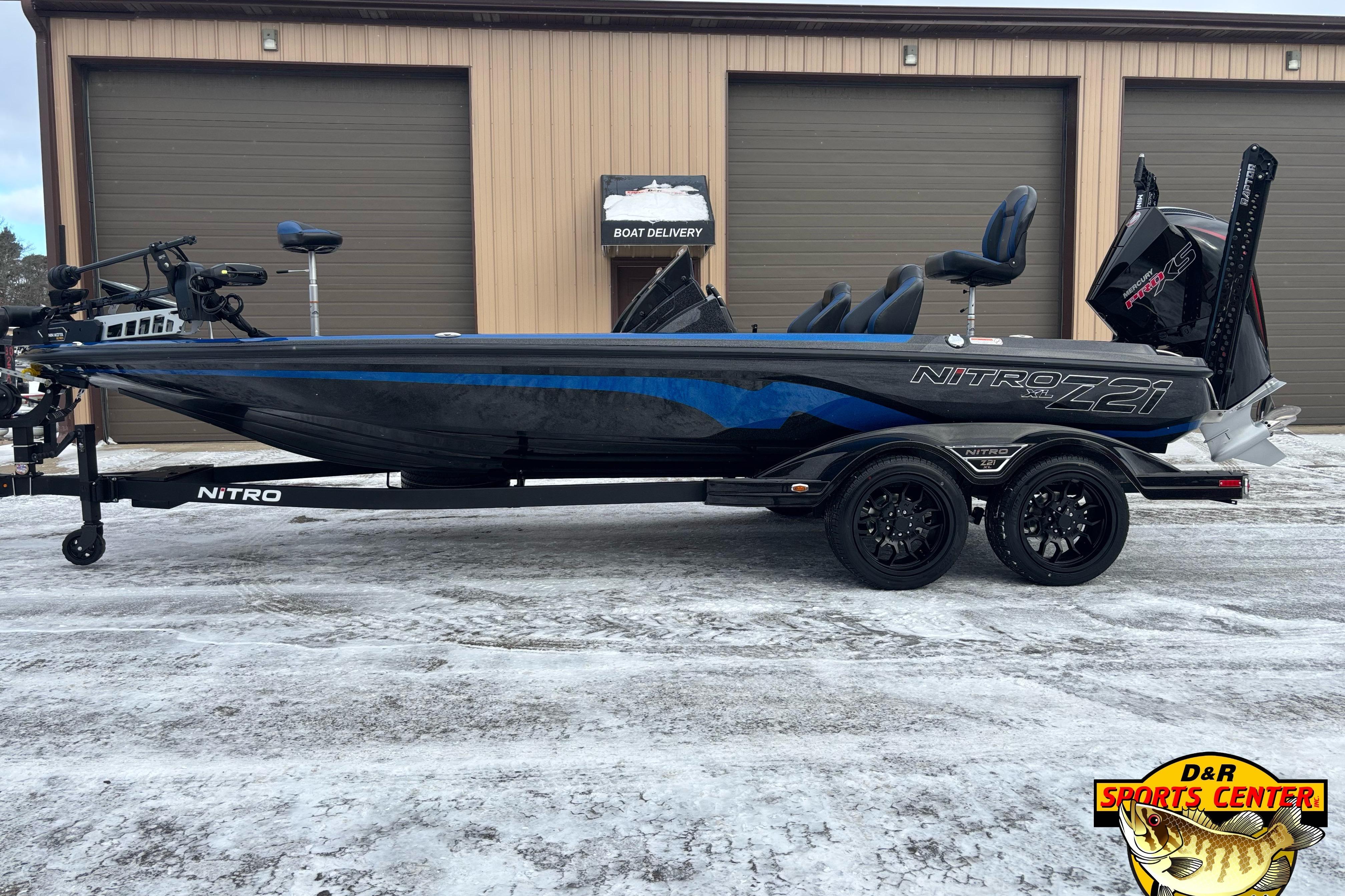 2026 Nitro Z21 XL boat with sleek design, parked on snowy ground outside a garage.