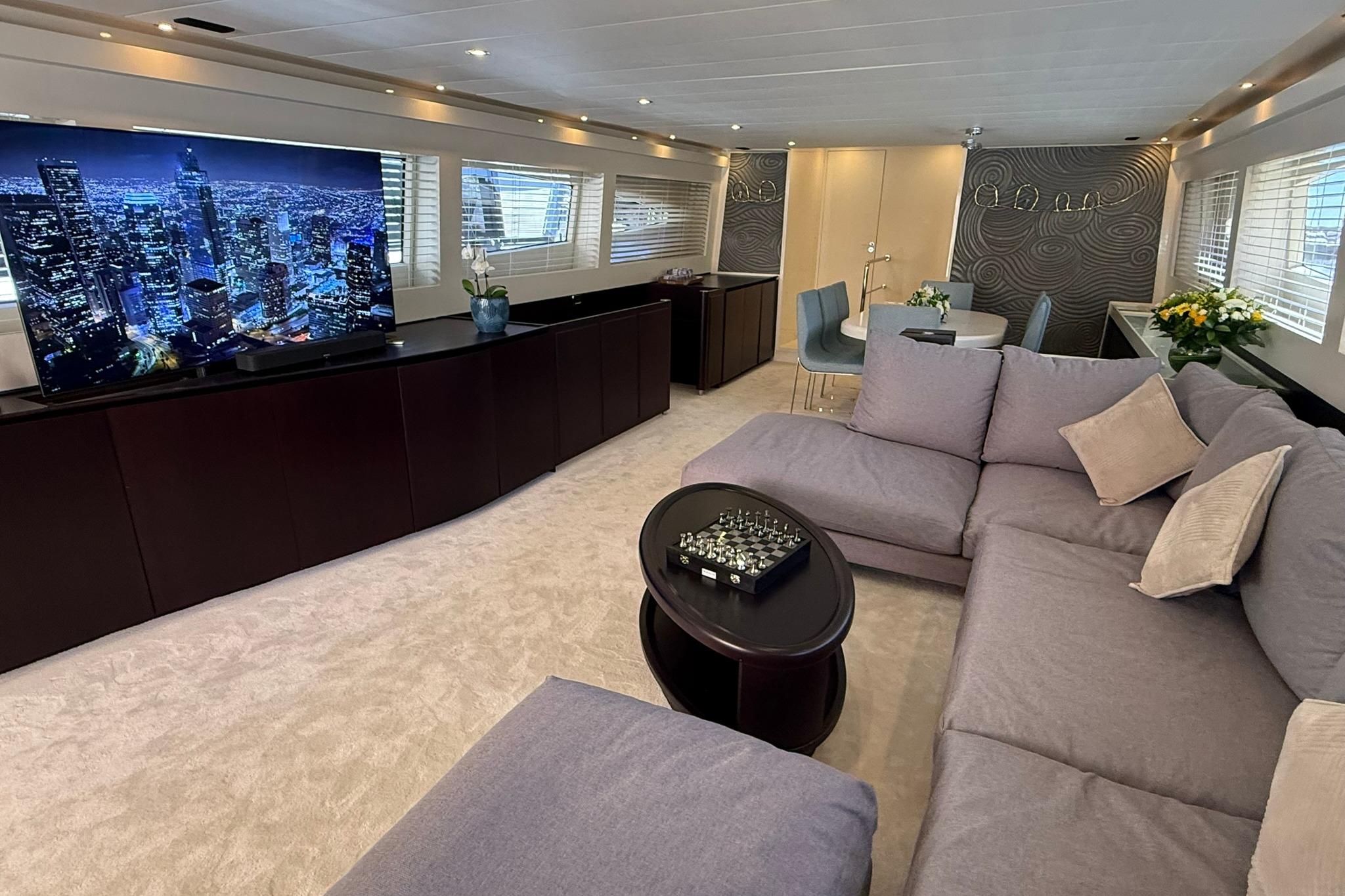 Luxurious interior of 2007 Canados 86 yacht with plush seating and large TV.