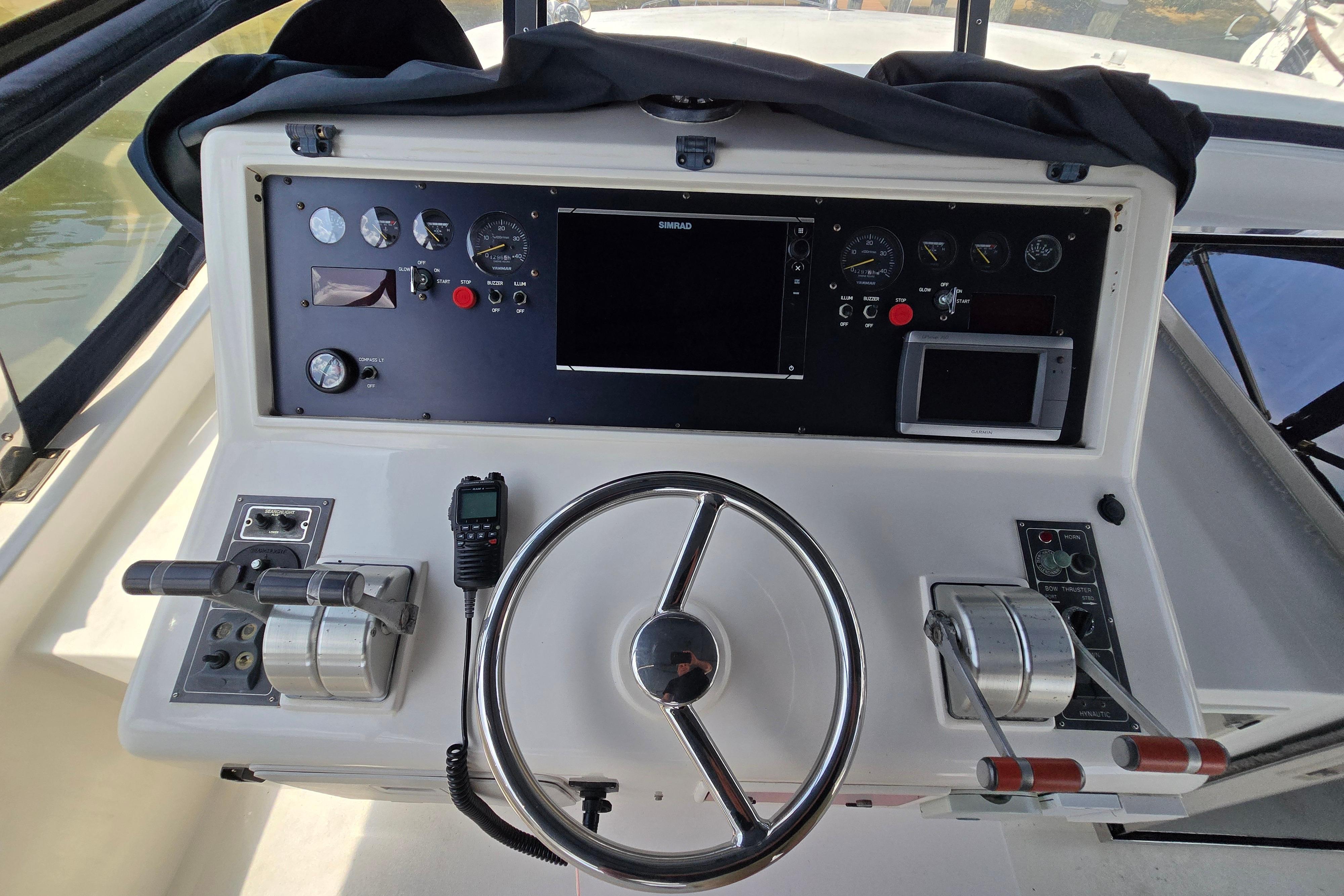 Control panel of a 2004 Grand Harbour 58 yacht with steering wheel and navigation instruments.