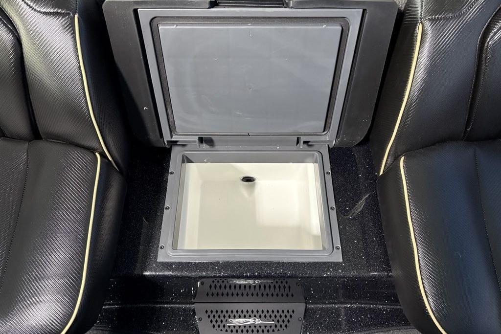 2026 Skeeter ZXE21 boat interior with open storage compartment between black seats.