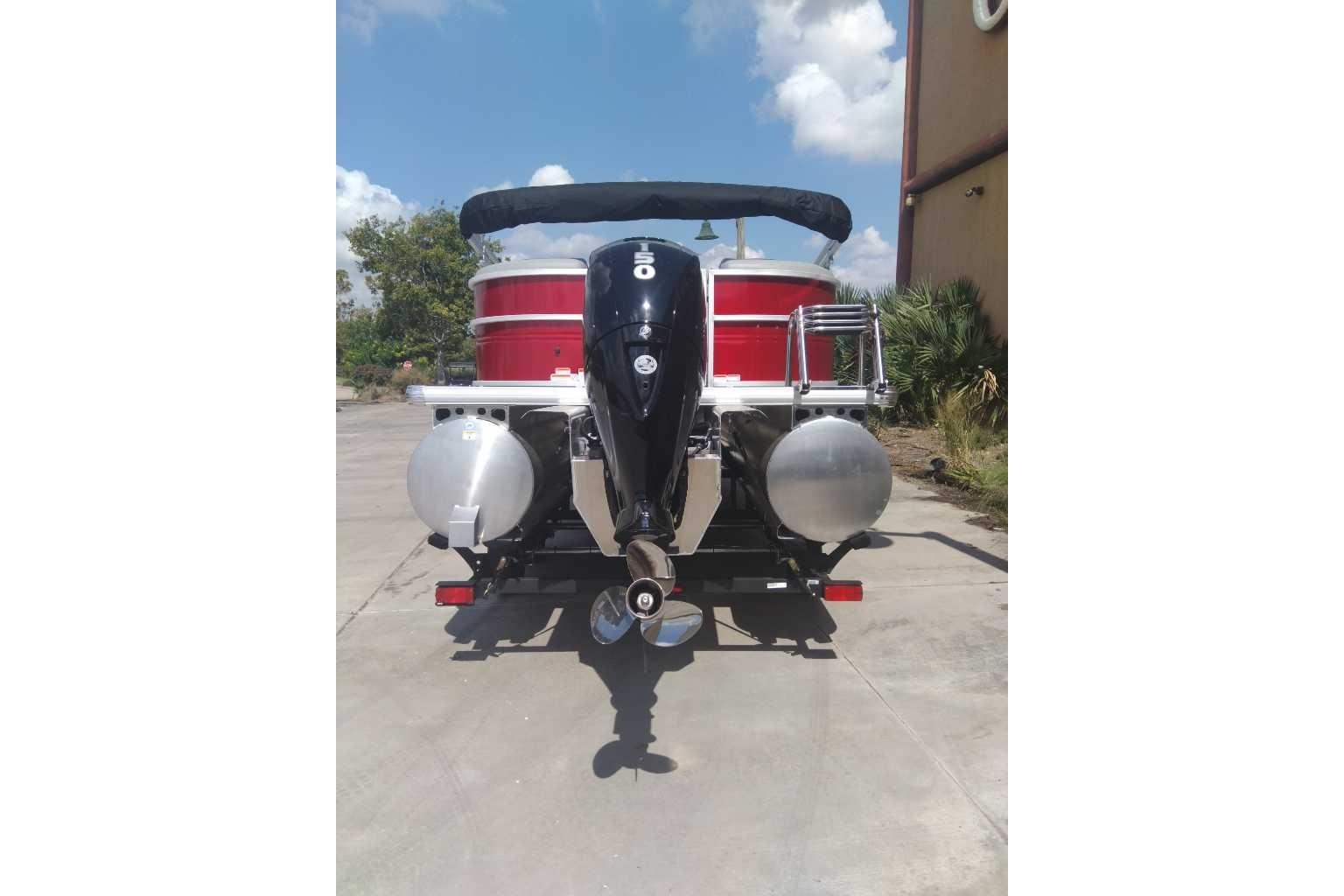 2026 Sun Tracker Party Barge 22 XP3 pontoon boat, rear view with motor, outdoors.