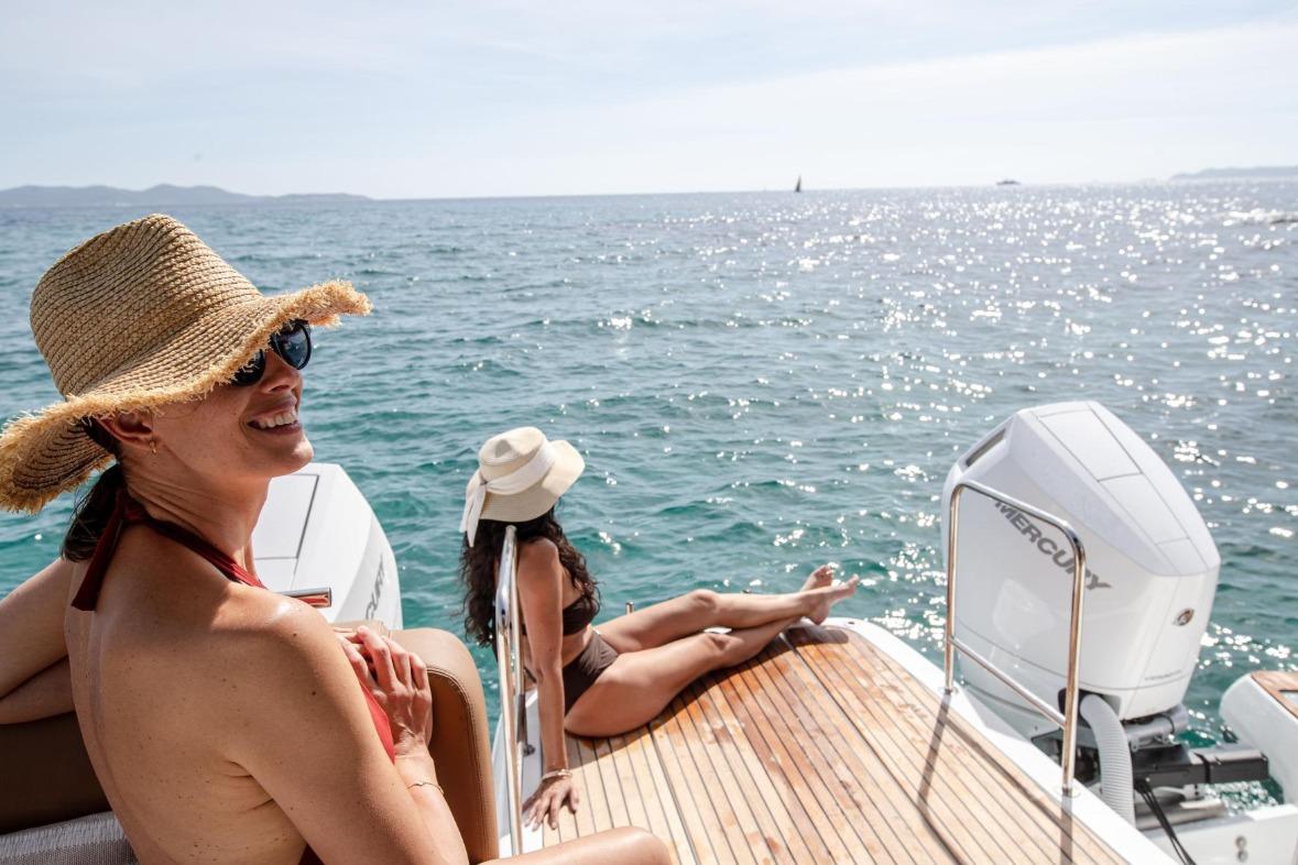 Women relaxing on a 2026 Jeanneau TH38 yacht, enjoying sunny ocean views.
