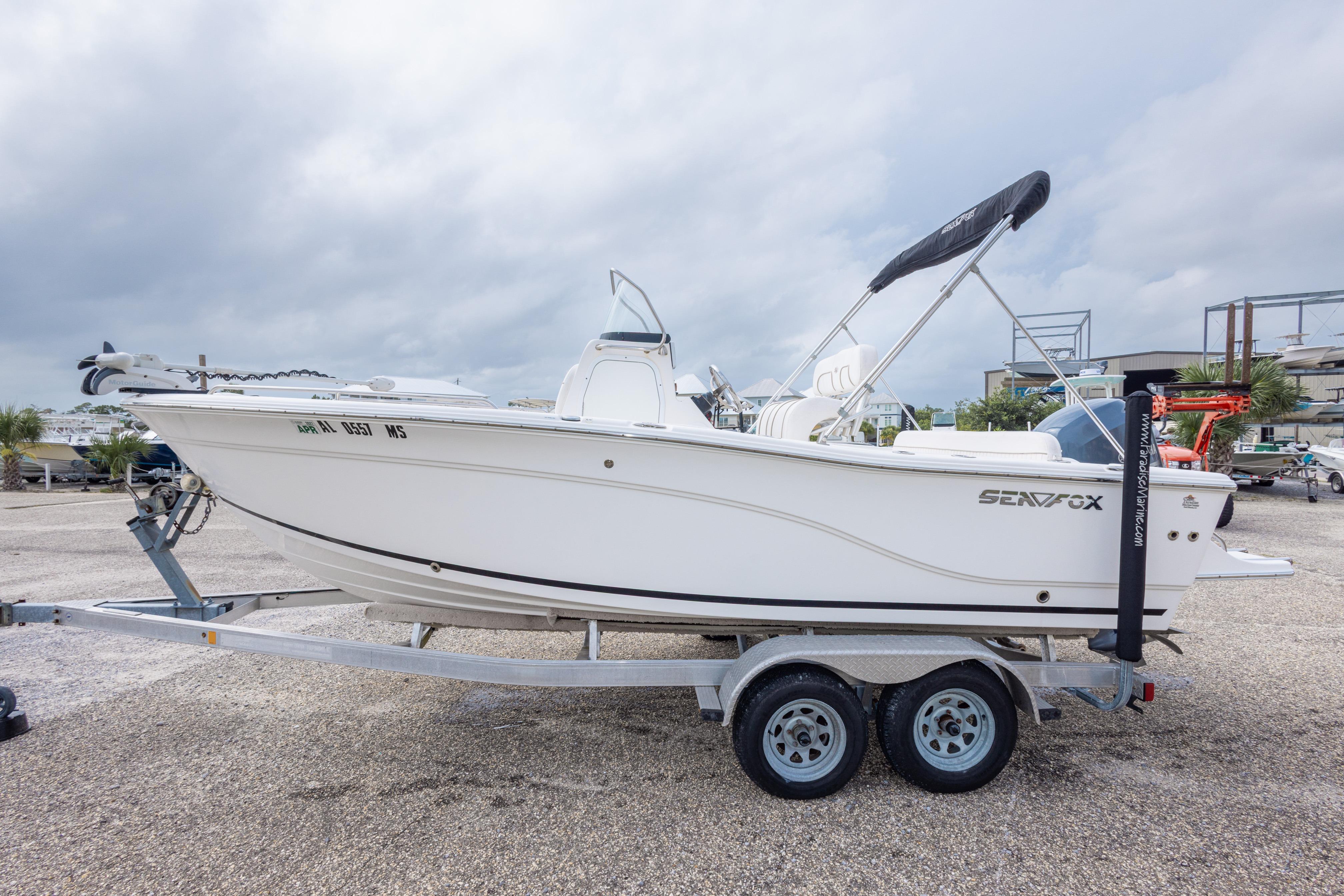 2014 Sea Fox 209 Commander boat on trailer, parked outdoors under cloudy sky.