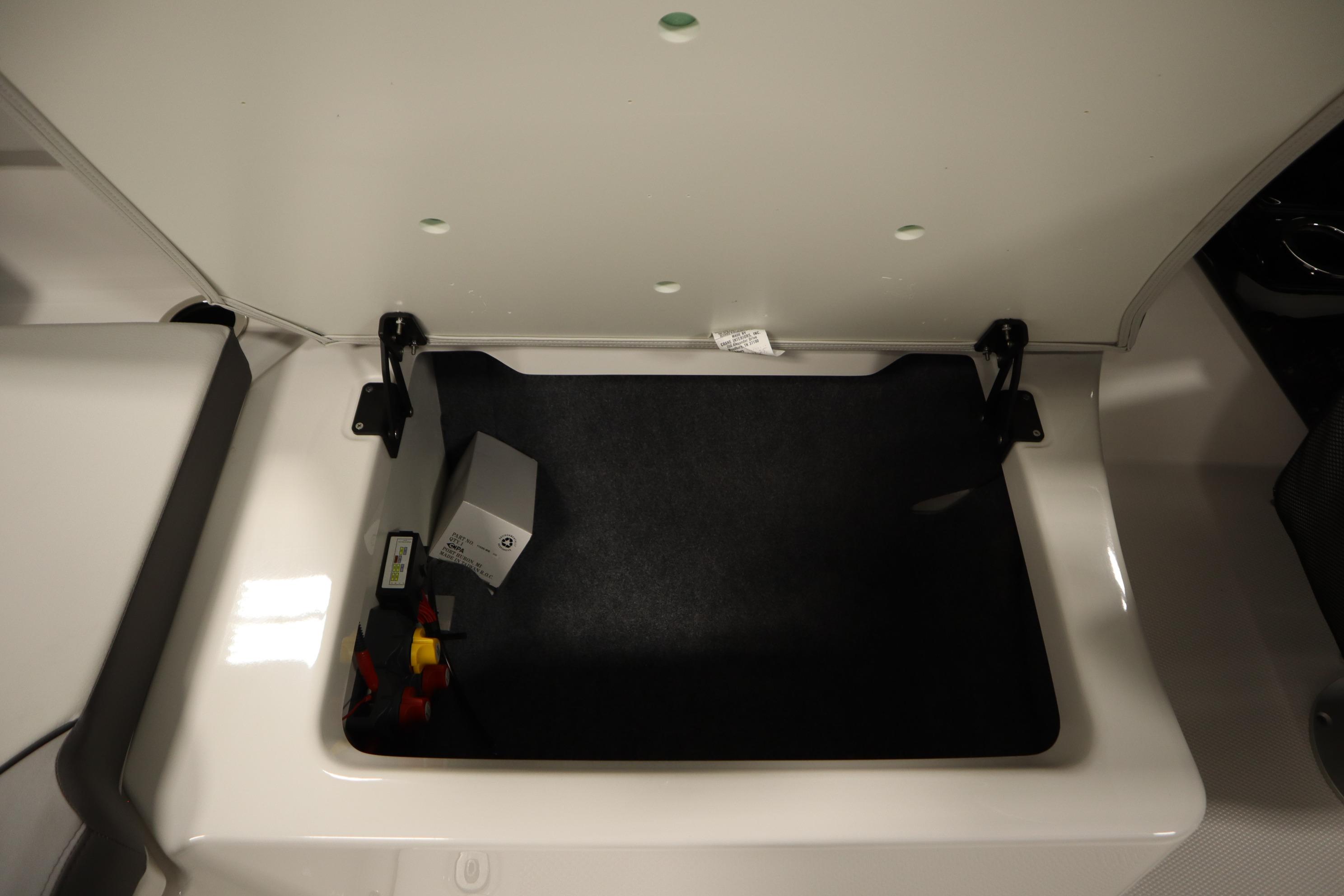 Open storage compartment in 2026 Yamaha Boats AR250, showcasing interior space and components.