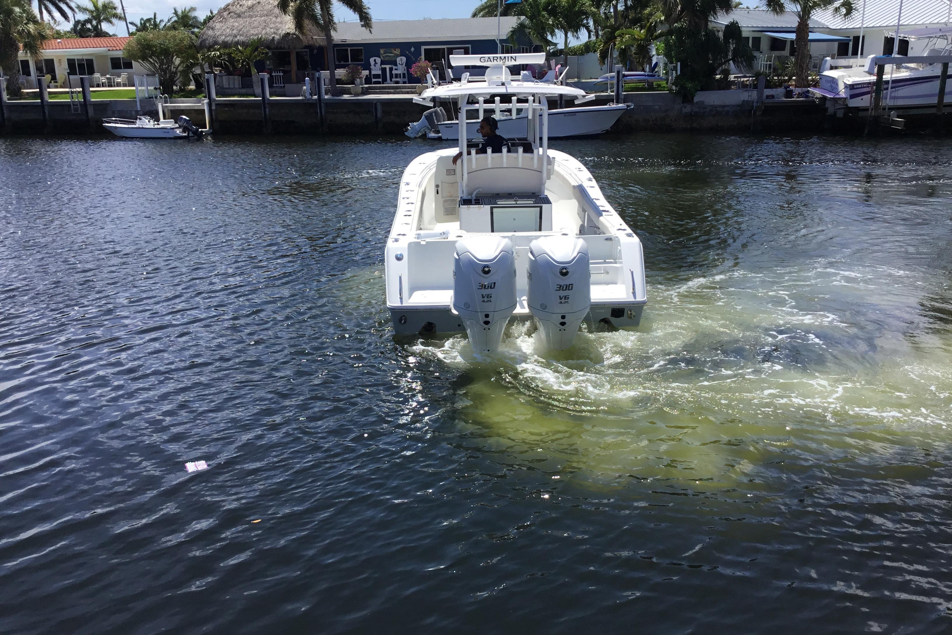 2024 Sea Hunt Gamefish 28 Coffin Box boat cruising in a canal with twin engines.