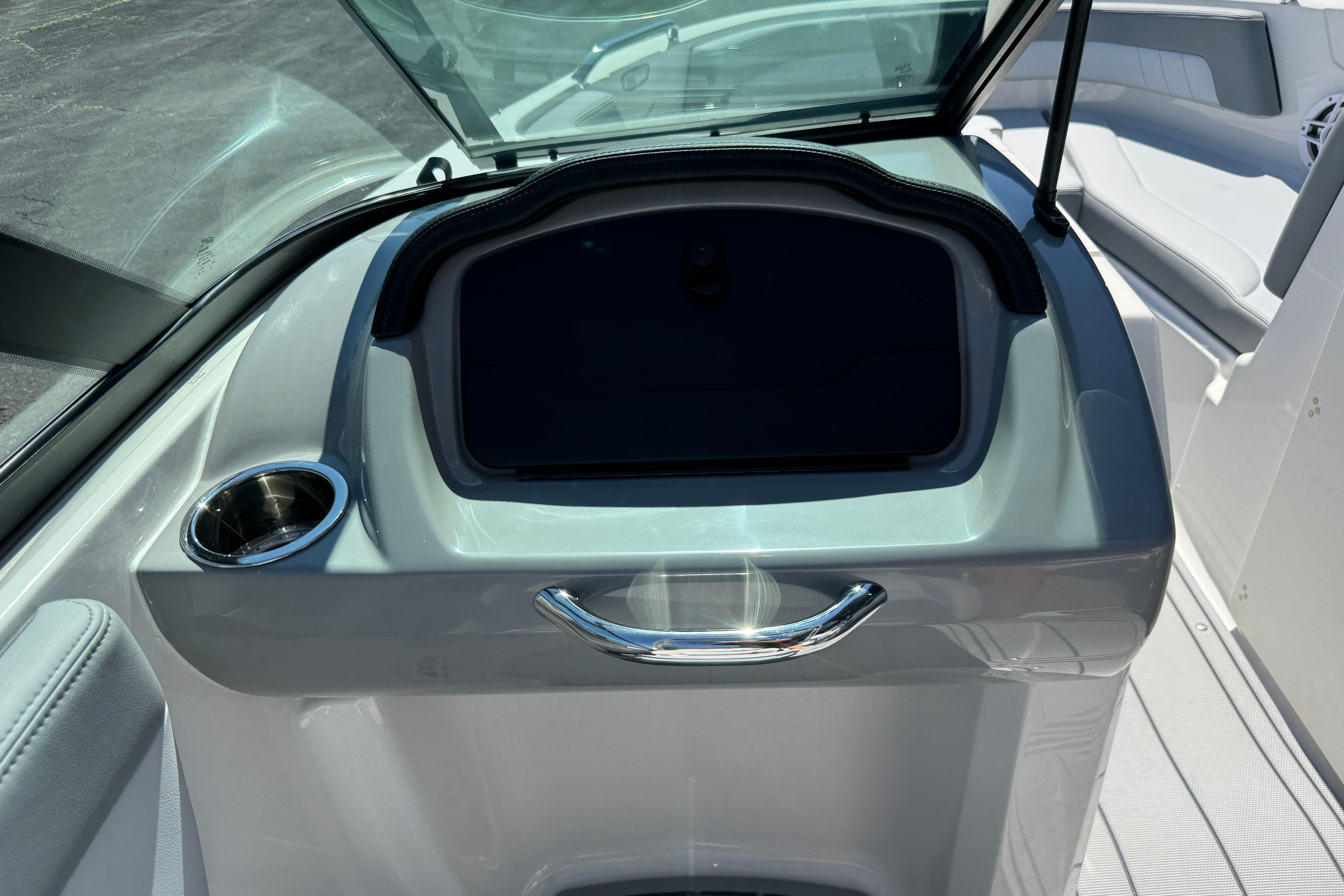 2026 Chaparral 21 SSi boat interior with storage compartment and cup holder.