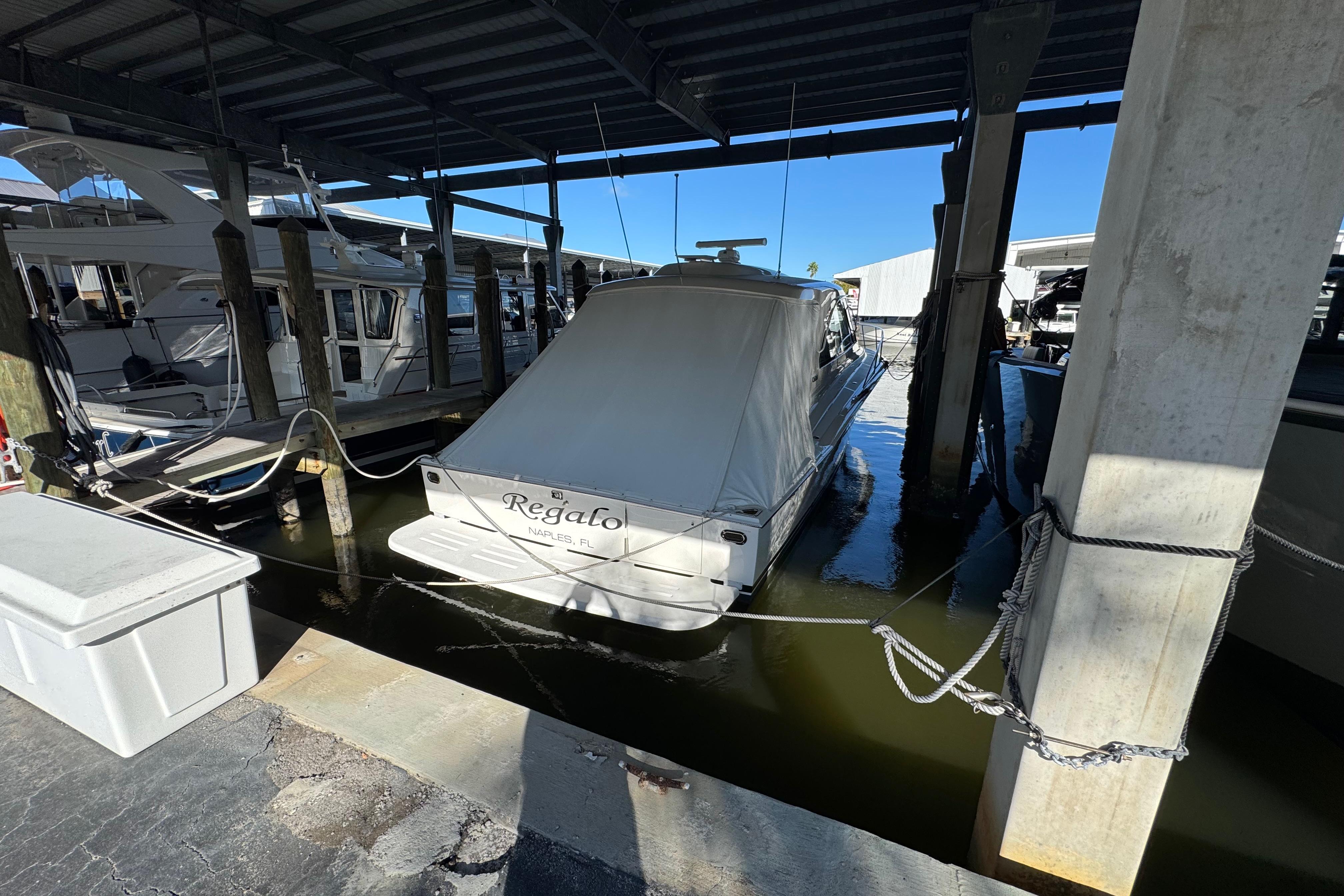 2013 Cabo 44 Hardtop Express docked in covered marina slip.