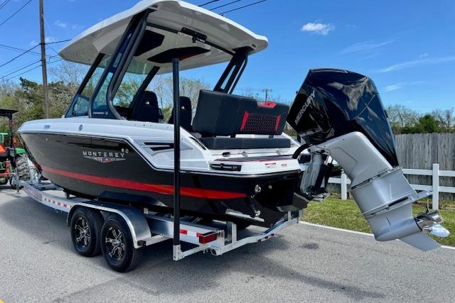 2026 Monterey Elite 25 OB boat on trailer, featuring sleek design and powerful outboard motor.