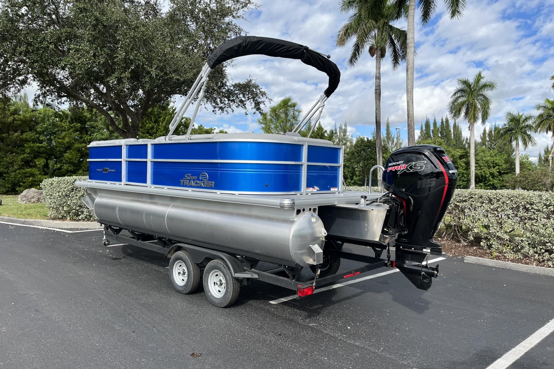 2026 Sun Tracker Party Barge 20 DLX pontoon boat on trailer, parked outdoors.