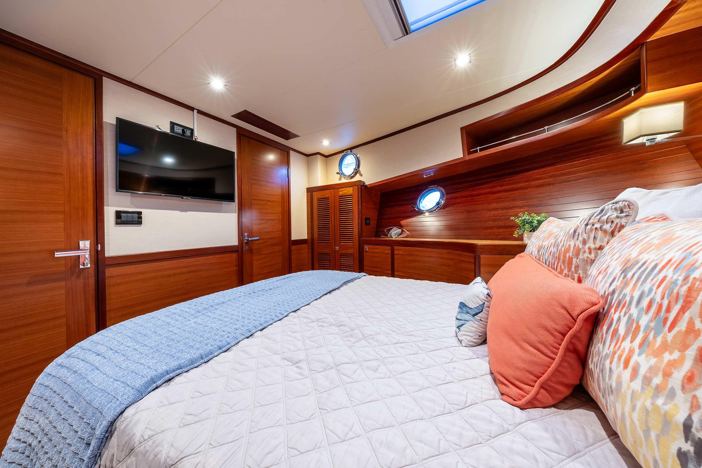 Luxurious cabin interior of 2019 Nordhavn 59 Coastal Pilot with cozy bedding and modern amenities.