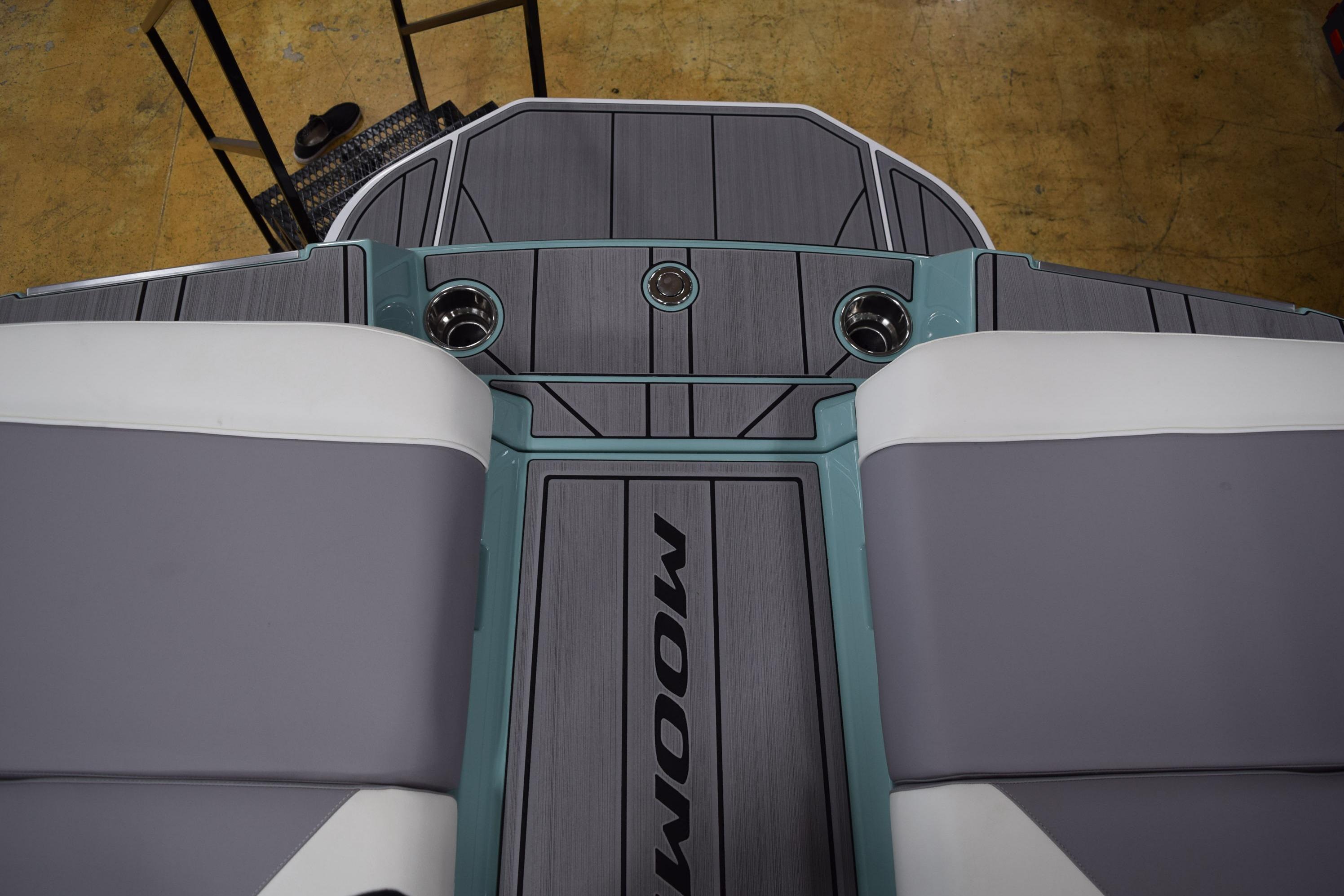 2025 Moomba Mojo boat interior with gray and white seating, cup holders, and sleek design.