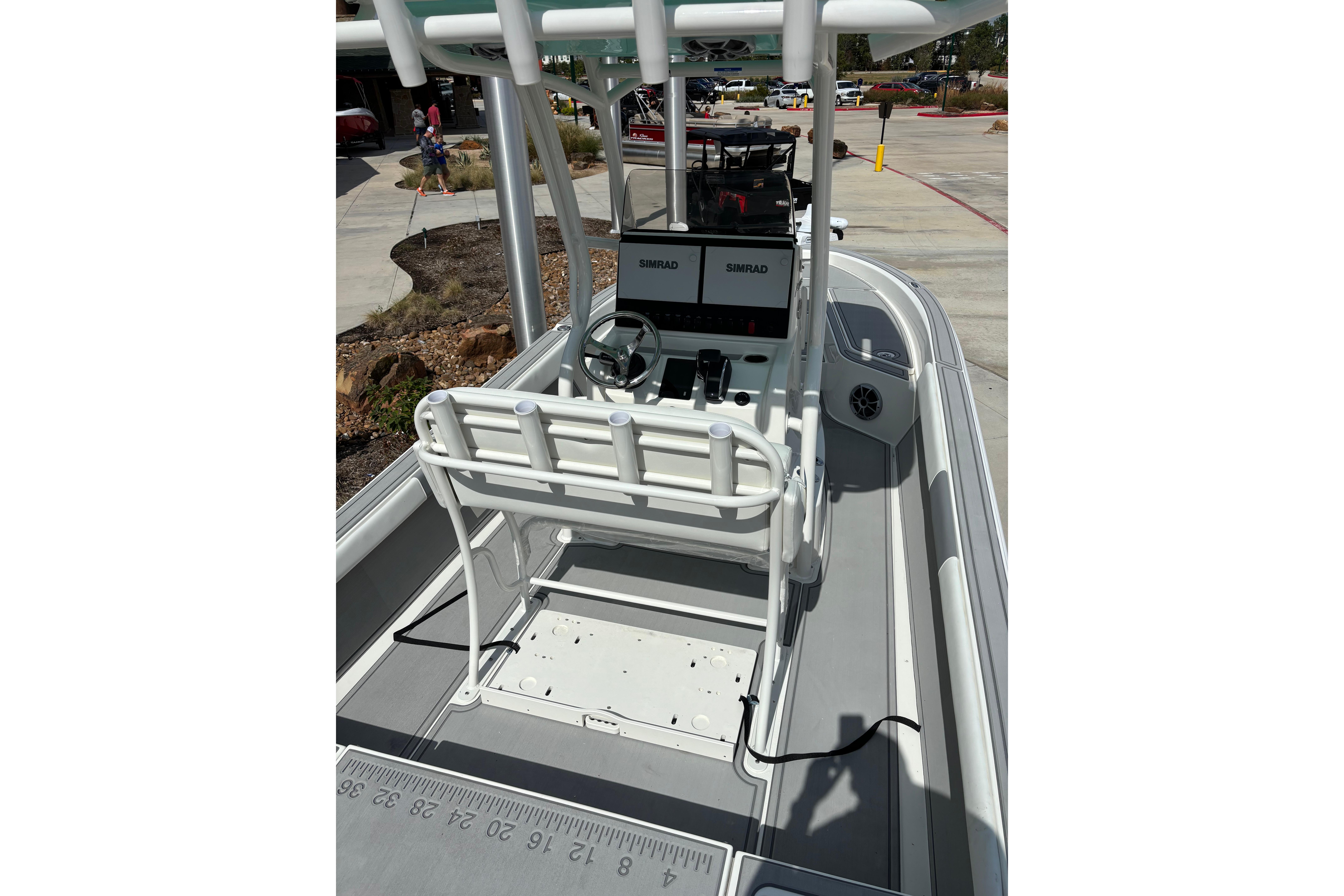 2026 Mako 24 APEX boat interior with steering console and rod holders.