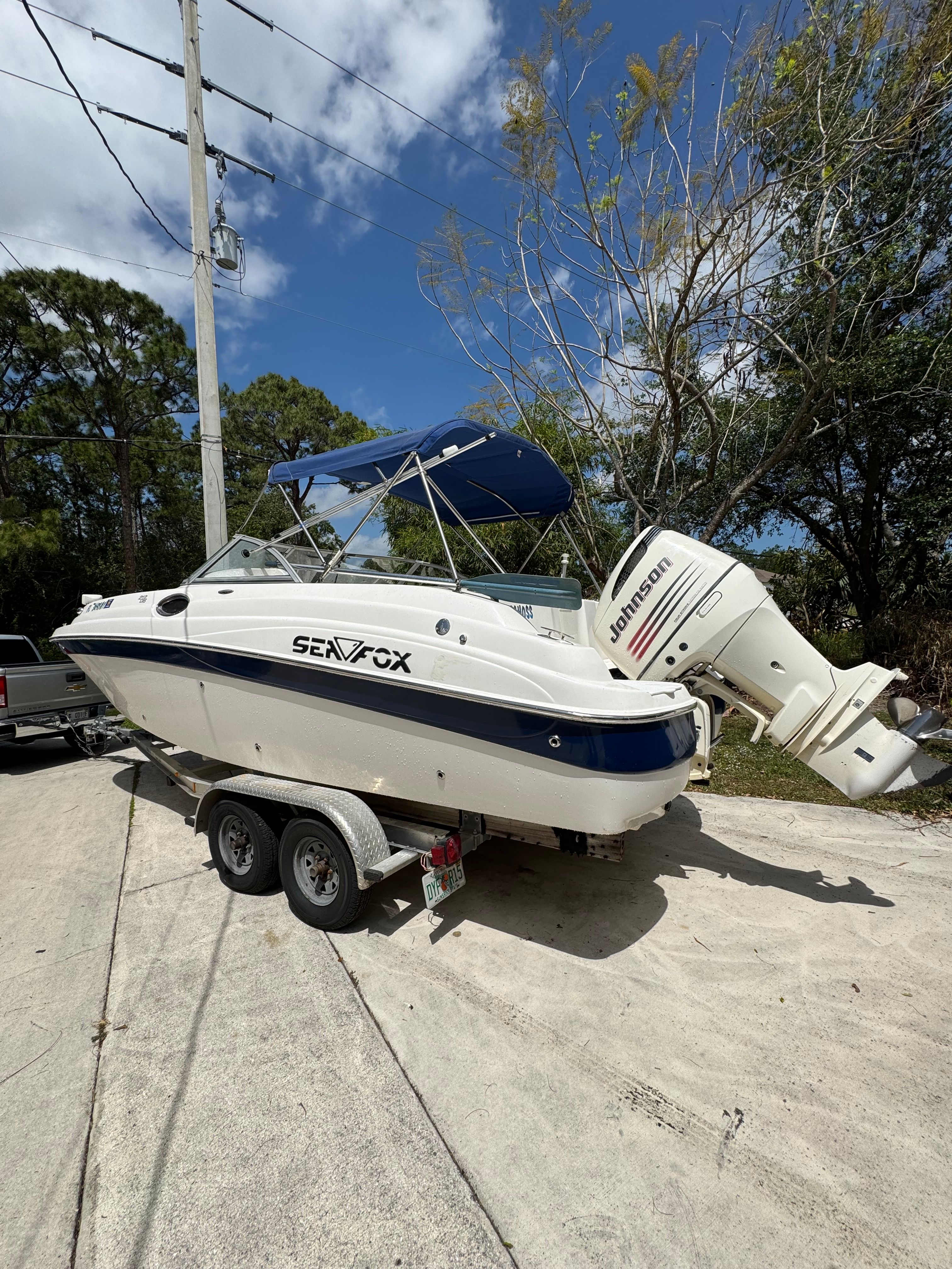 Boat on a trailer with an outboard motor.