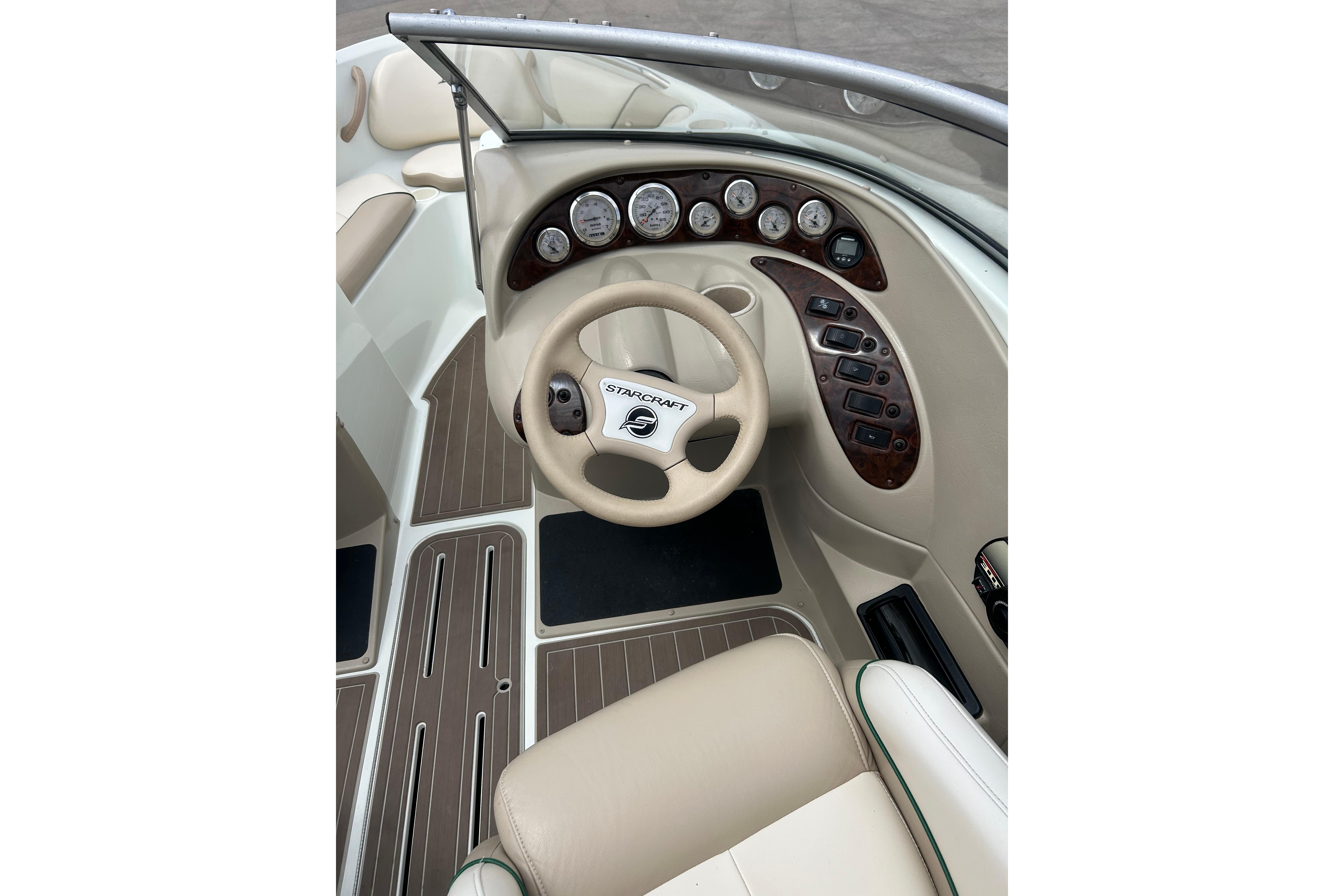 Cockpit of 2000 Starcraft 1810 boat with steering wheel and instrument panel.