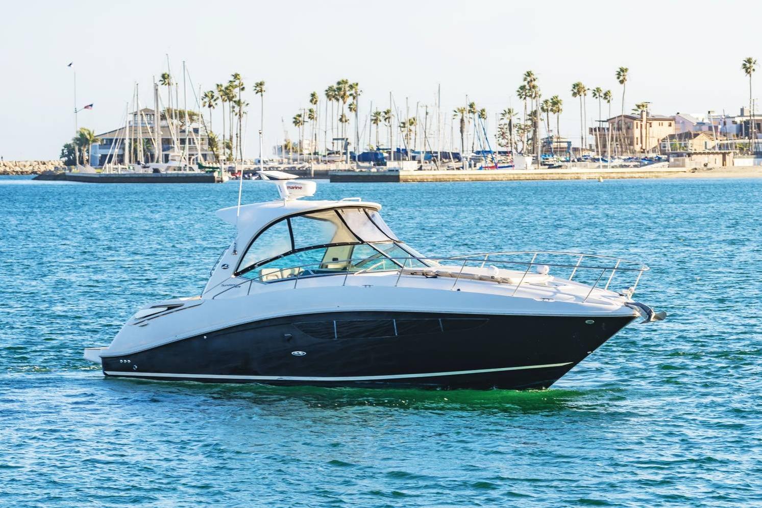 2016 Sea Ray 370 Express Cruiser on calm waters near marina.