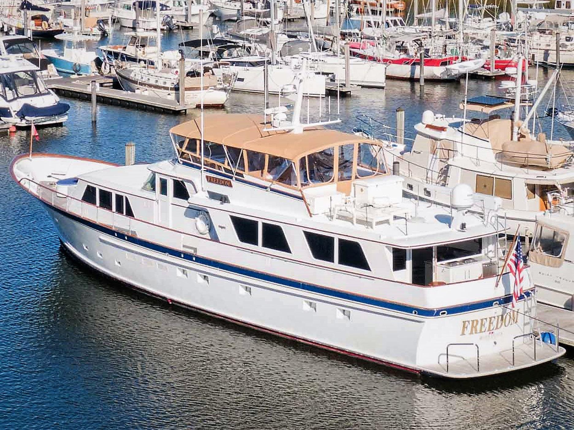1979 Burger Raised Pilothouse yacht docked in a marina, surrounded by other boats.