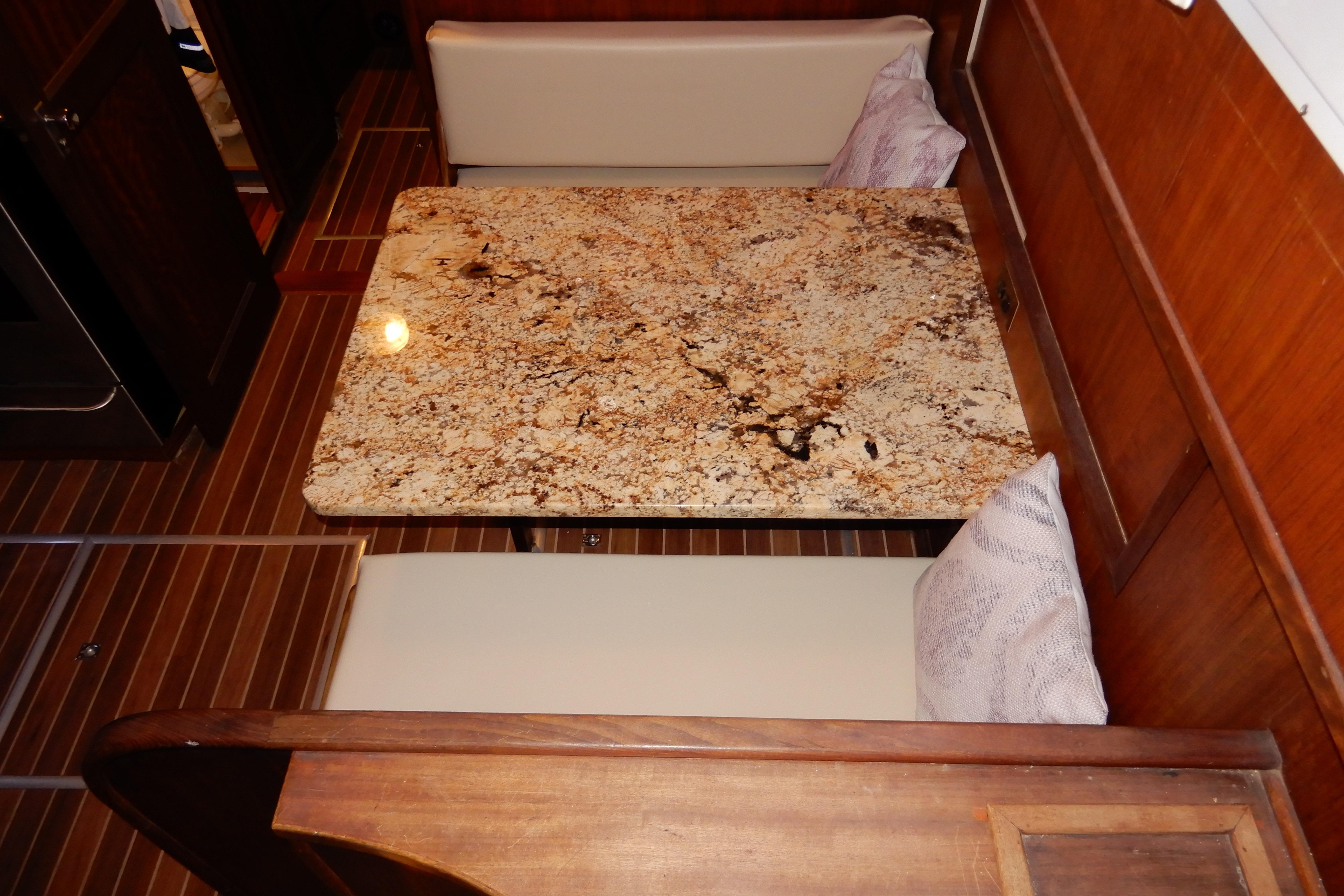 1974 Hatteras 53 Motor Yacht interior with granite table and cushioned seating.