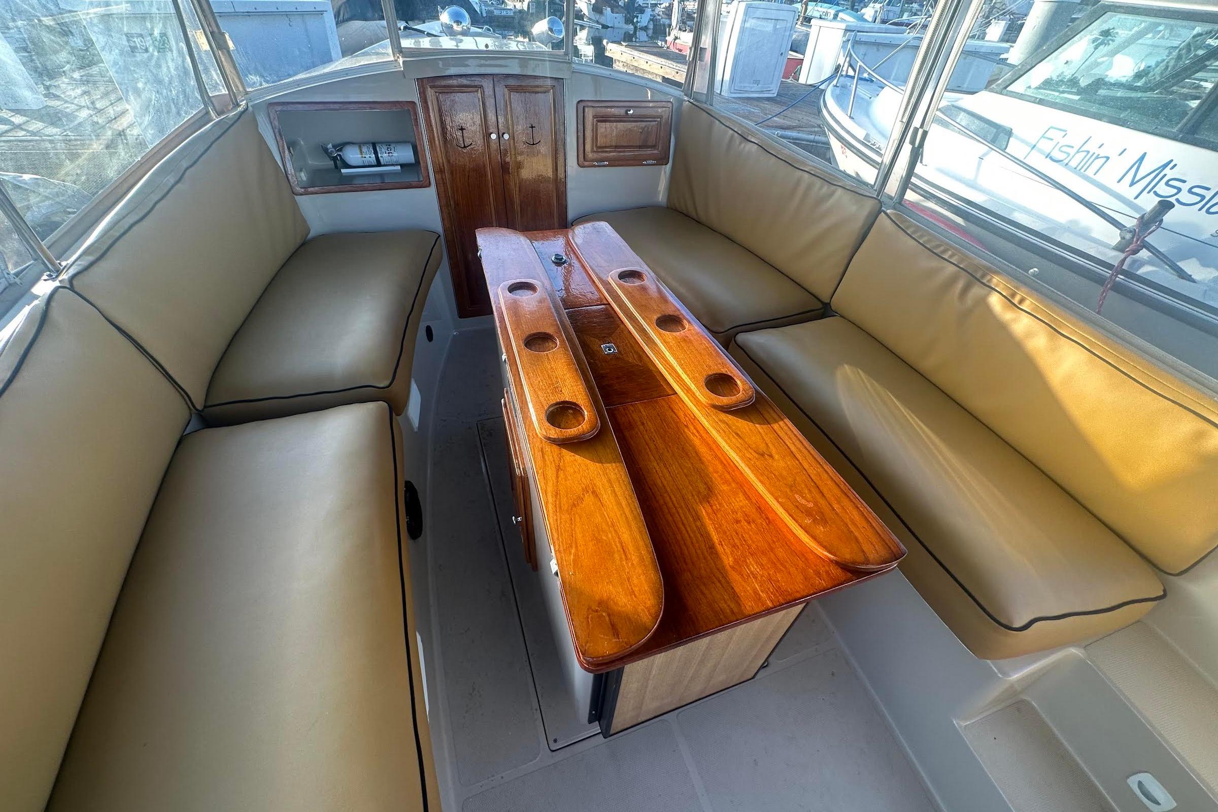 Interior of 2007 Duffy 22 Electric boat with beige seating and wooden table.