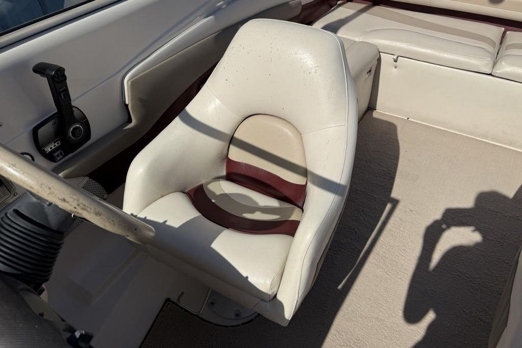 1999 Glastron GT 225 boat interior with white captain's chair and control panel.