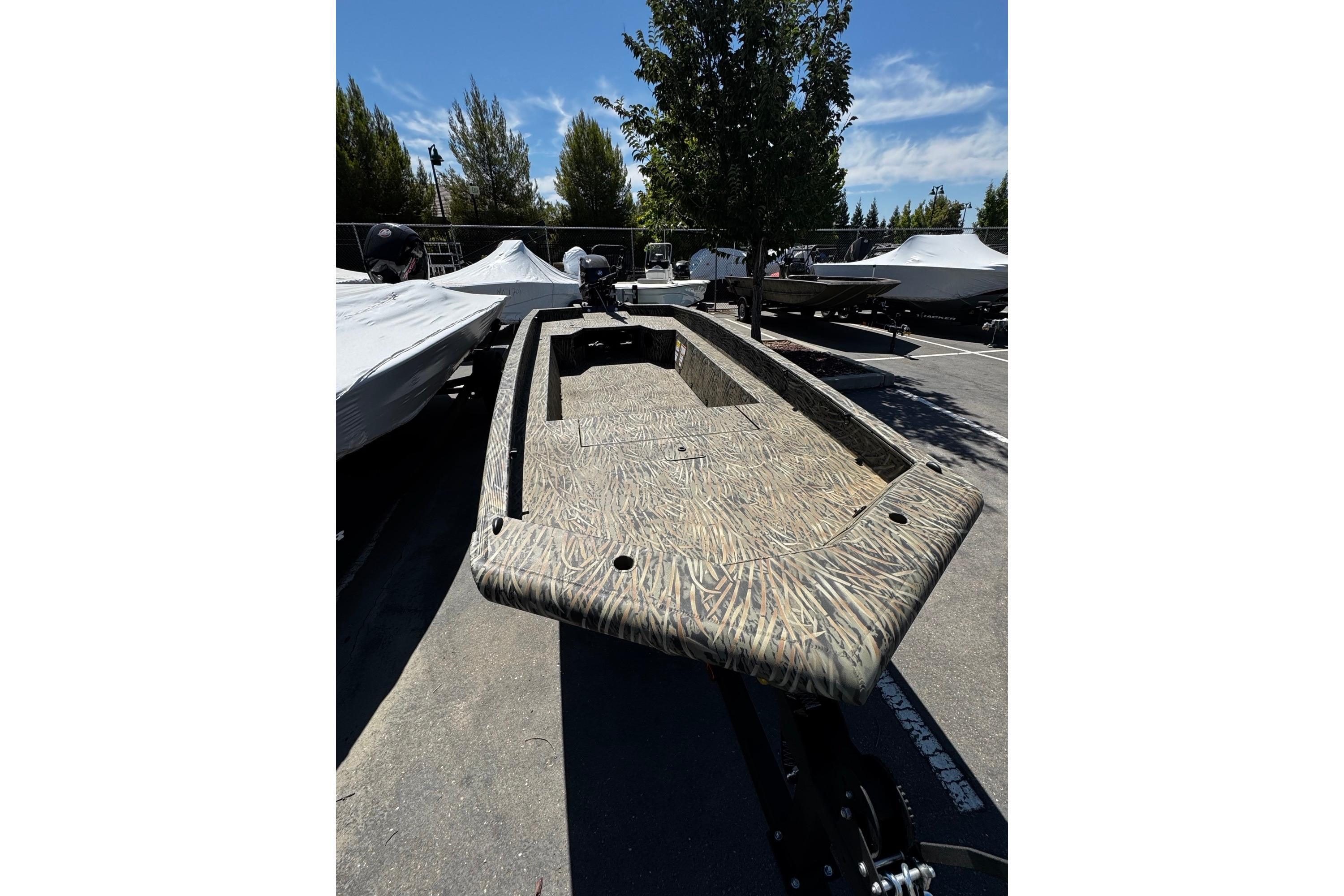 2026 Tracker Grizzly 1650 T Prairie Wings Edition boat in parking lot, camo design.
